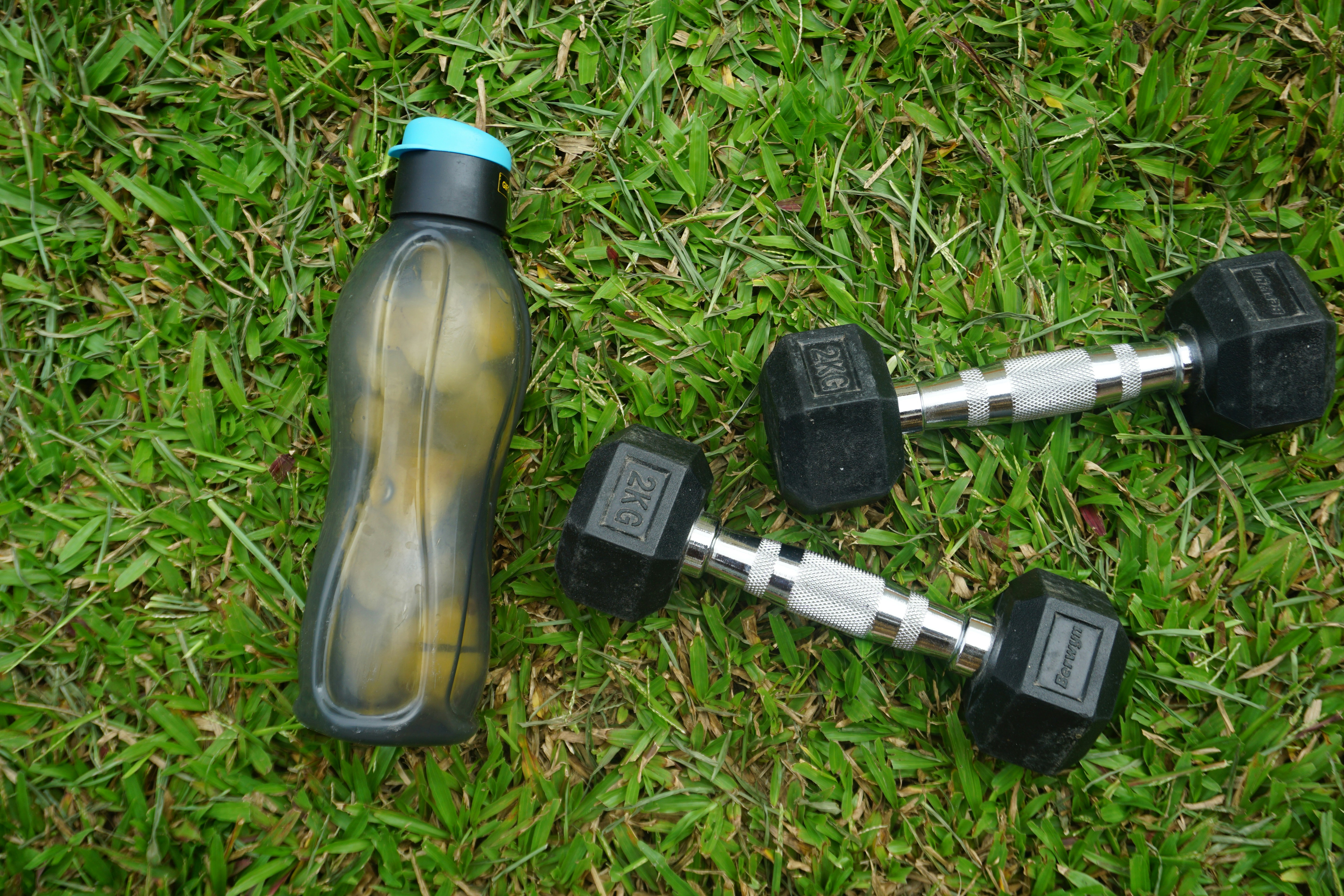 Close up of a foam roller and a water bottle on a gym floor, symbolizing recovery
