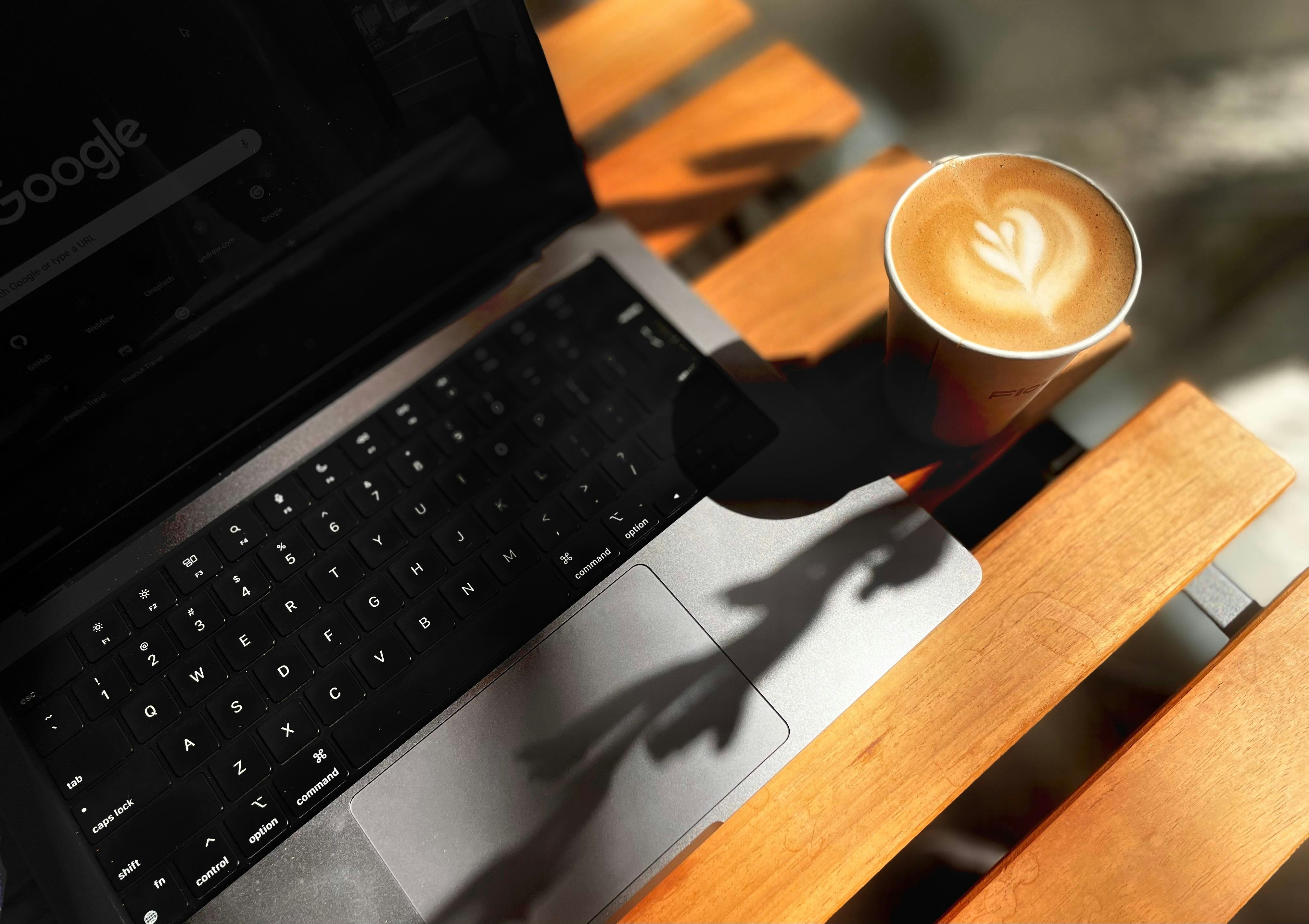 Young freelancer working on a laptop in a cafe with a coffee cup nearby