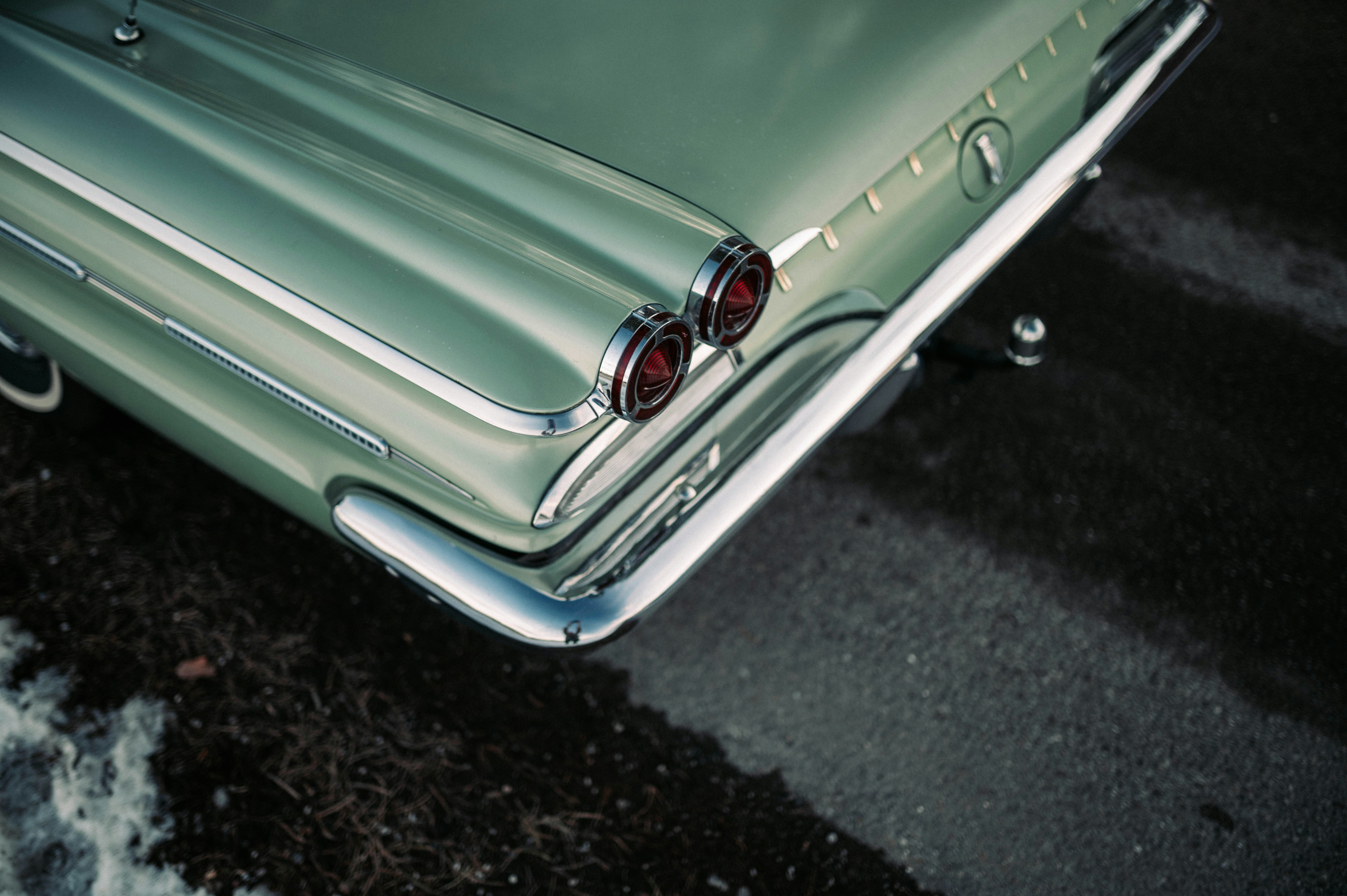 Close up detail of a perfectly polished chrome bumper of a vintage 1960s American car reflecting the sky