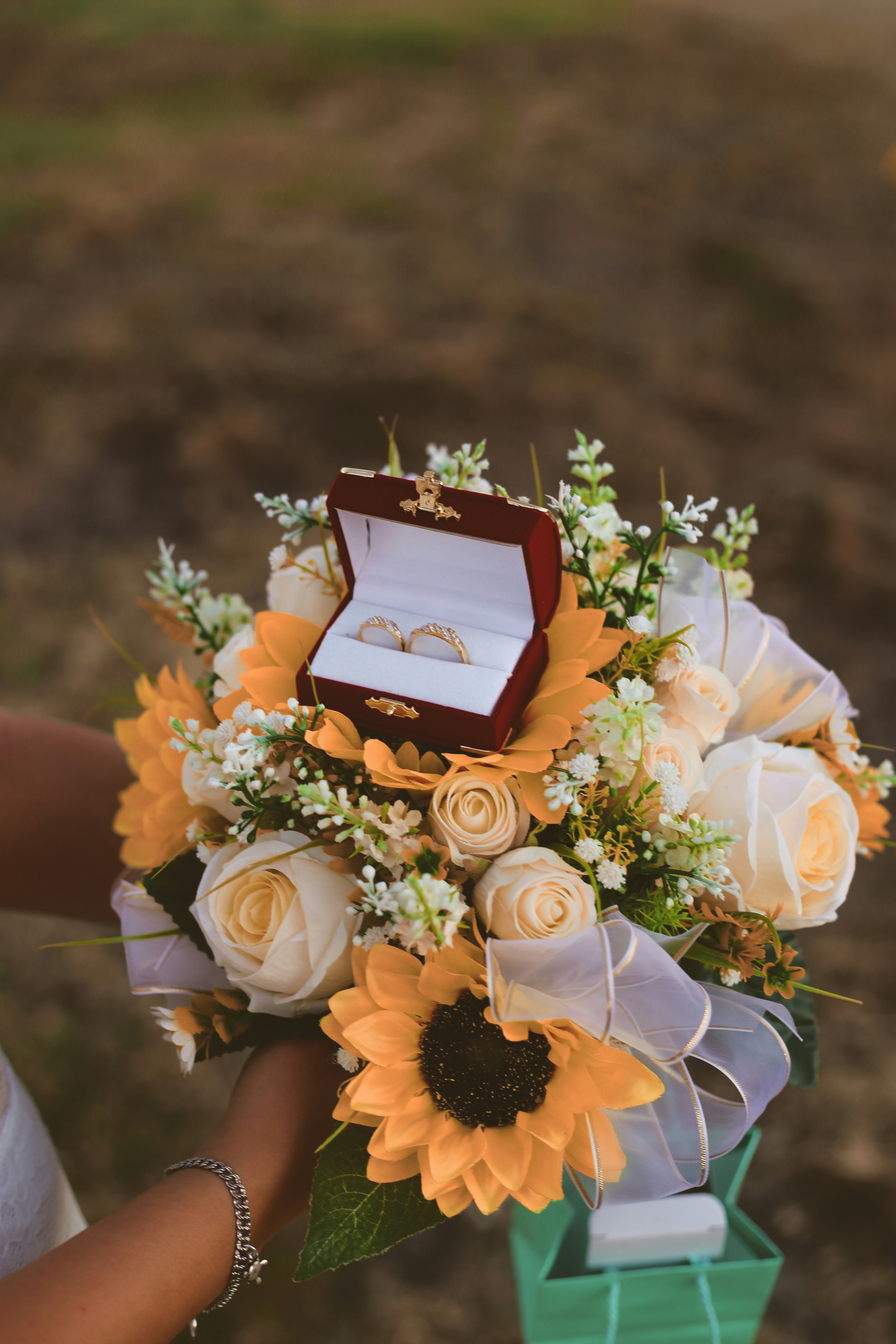 Close up detail of wedding rings and bouquet in soft light style fine art