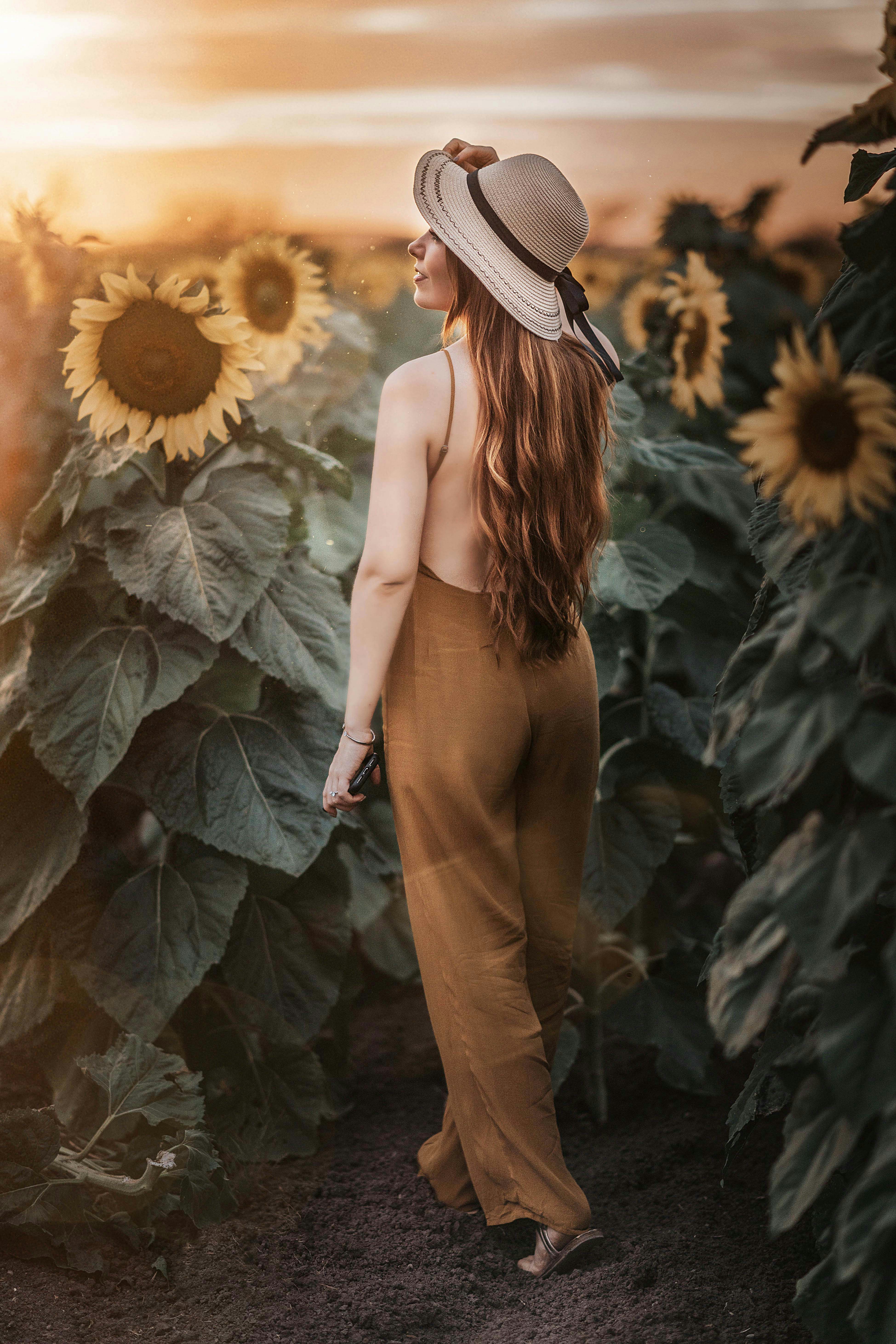 Woman wearing a floral dress running in a field at golden hour
