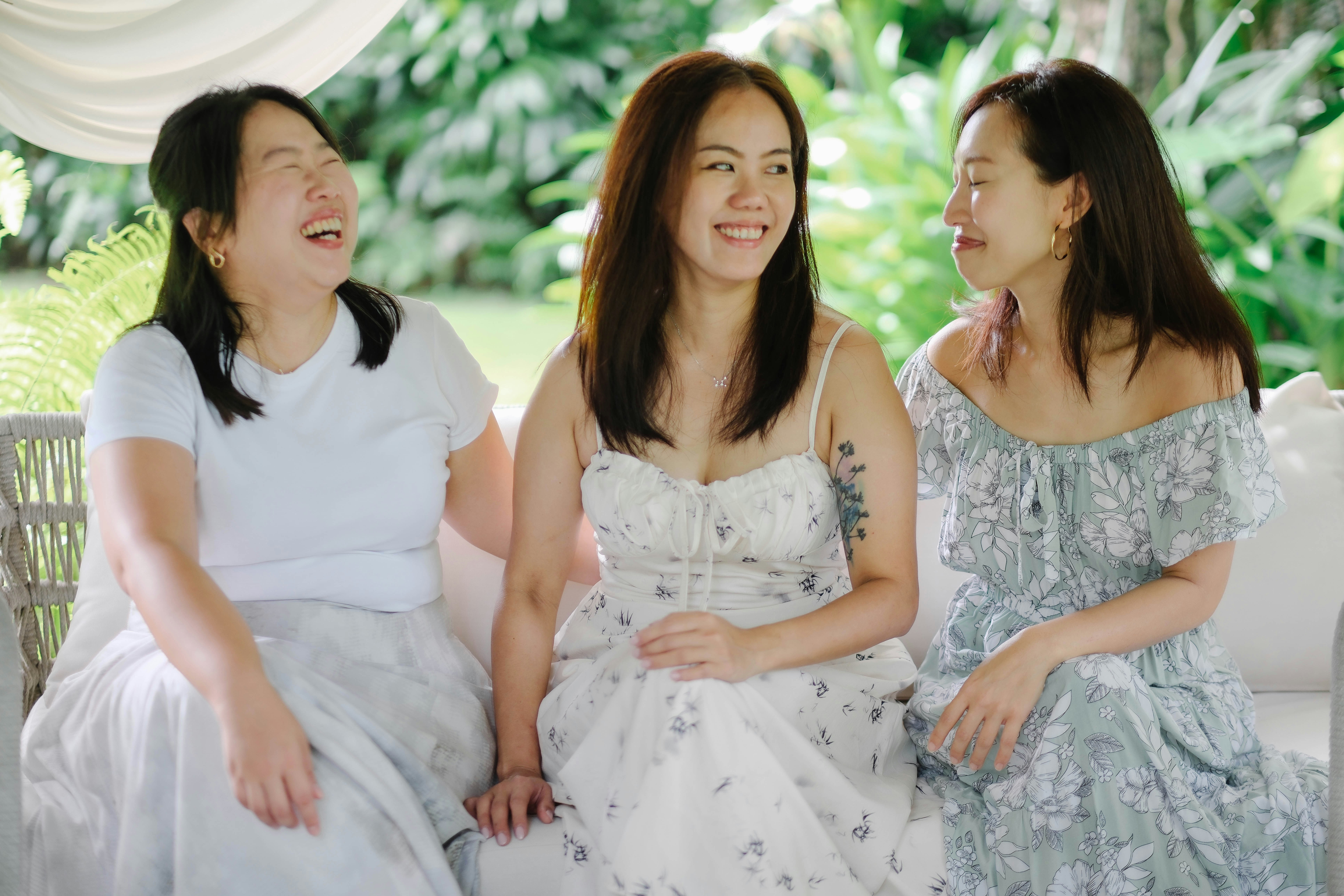 Close up of diverse women laughing together wearing denim and white shirts