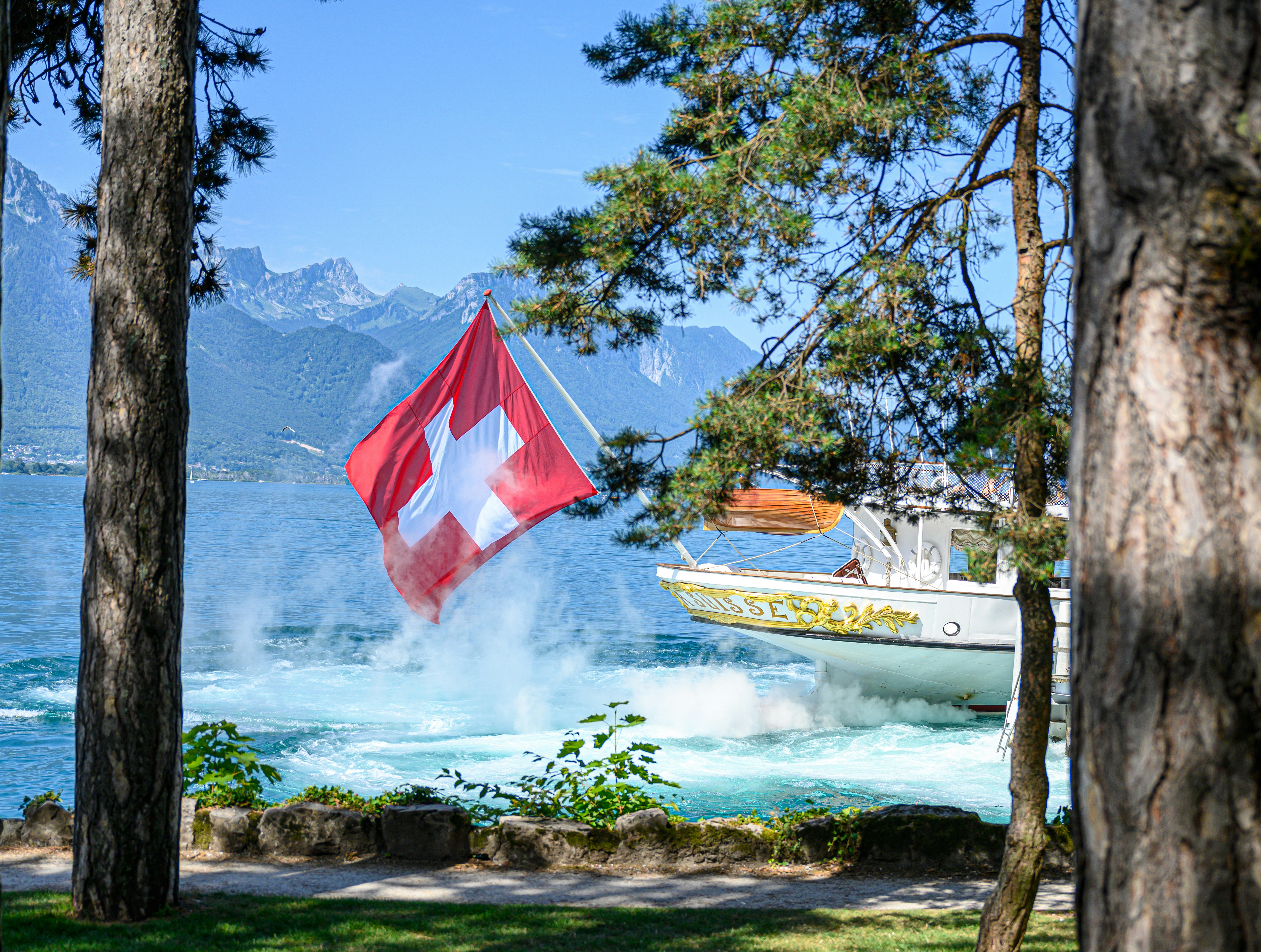 Swiss passport and identity card lying on a wooden table next to travel tickets