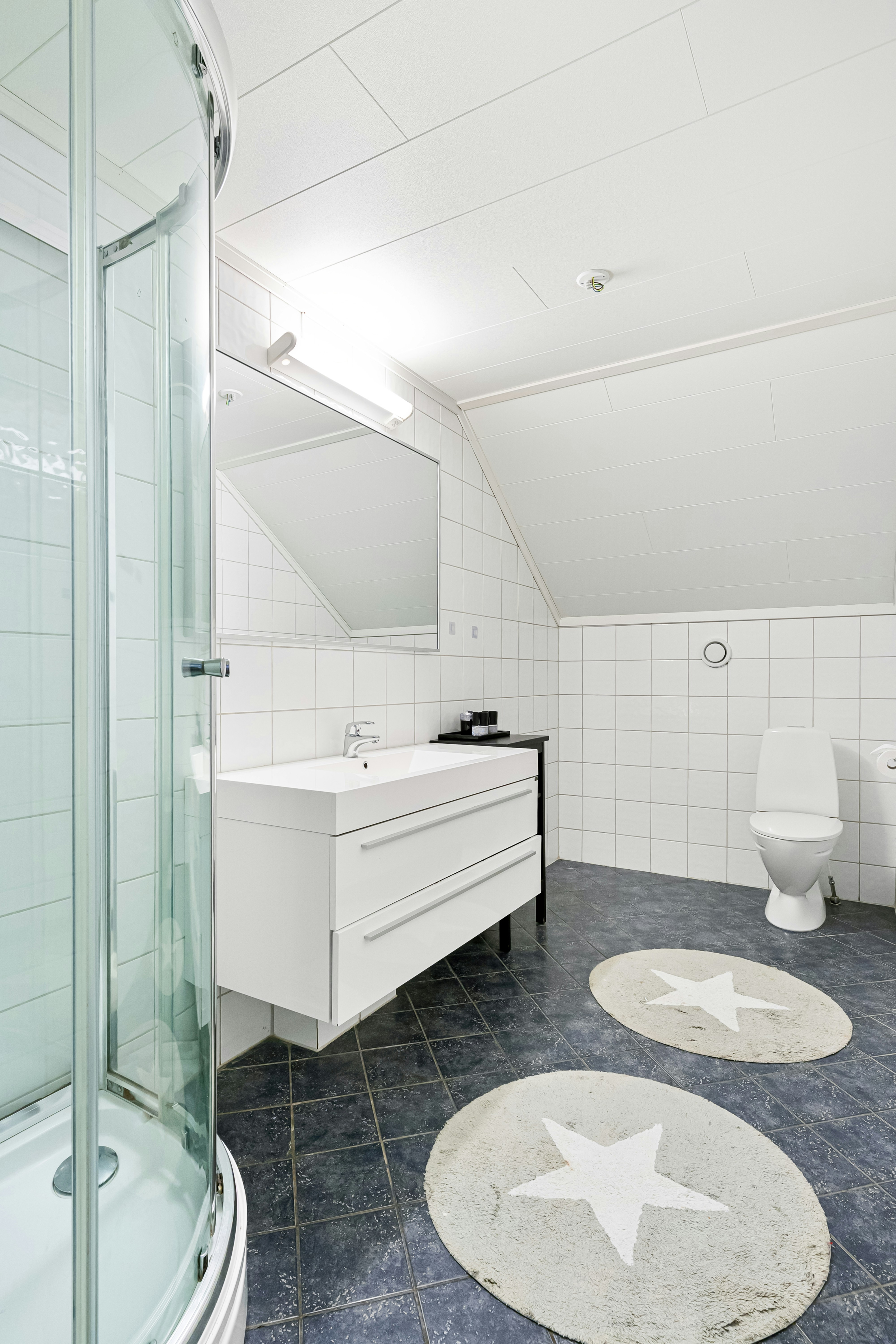 Modern bathroom interior with focus on clean white tiles and a sleek sink faucet, representing a newly renovated bathroom.