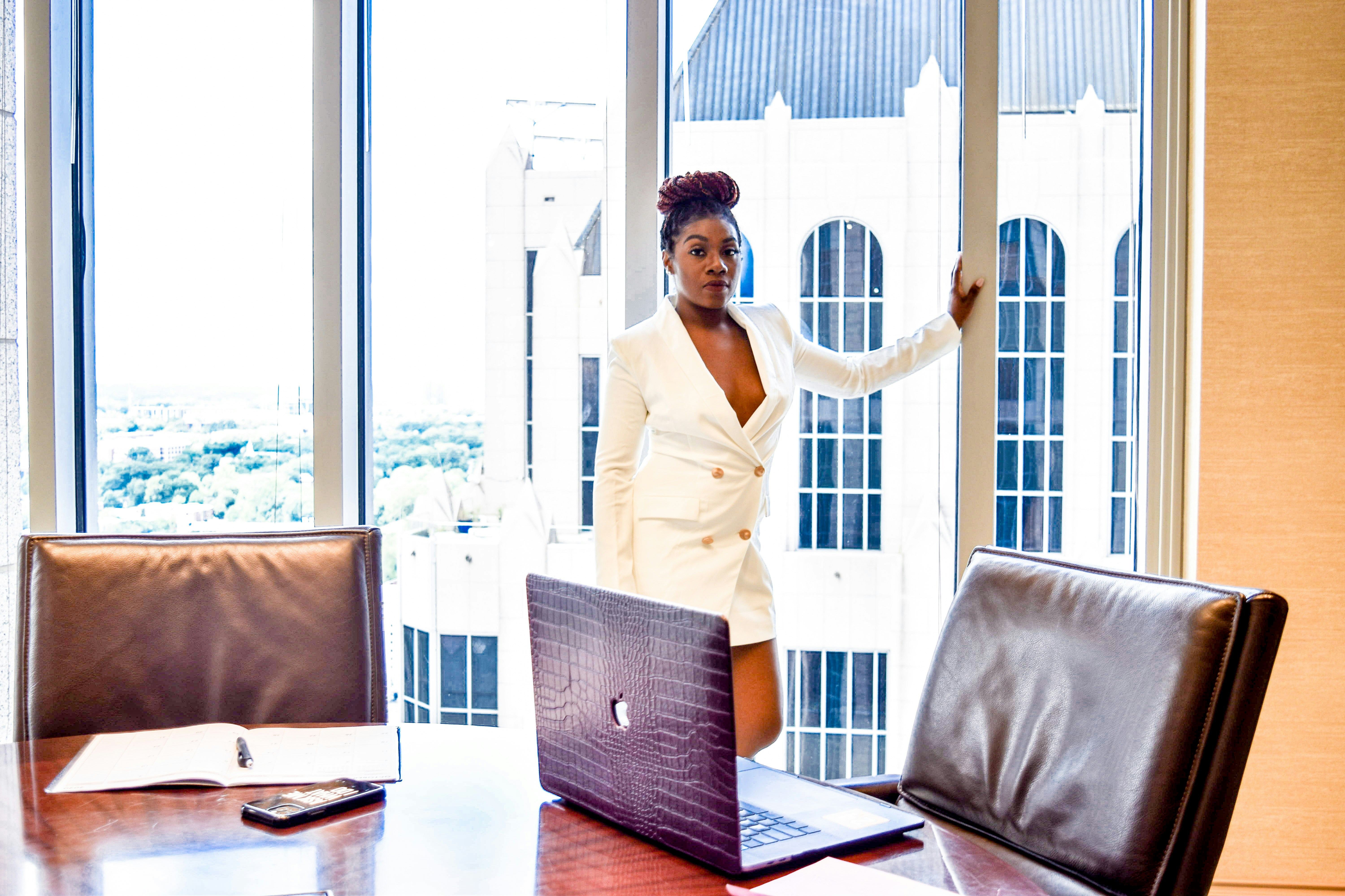 Business woman presenting a growth chart on a glass wall in a bright meeting room