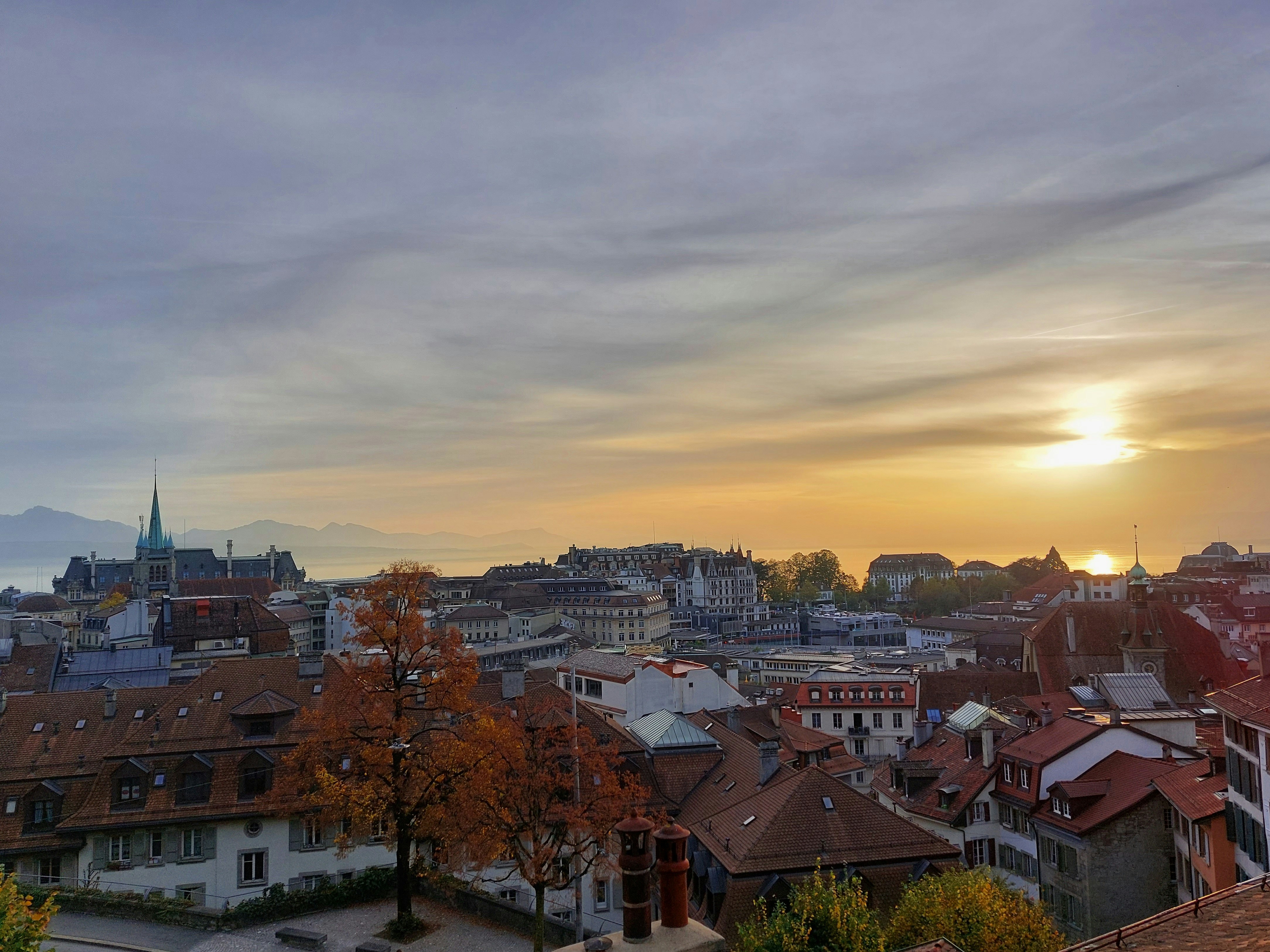 Urban portrait shoot in Lausanne, blurred city background, actor leaning against a textured wall, golden hour light.