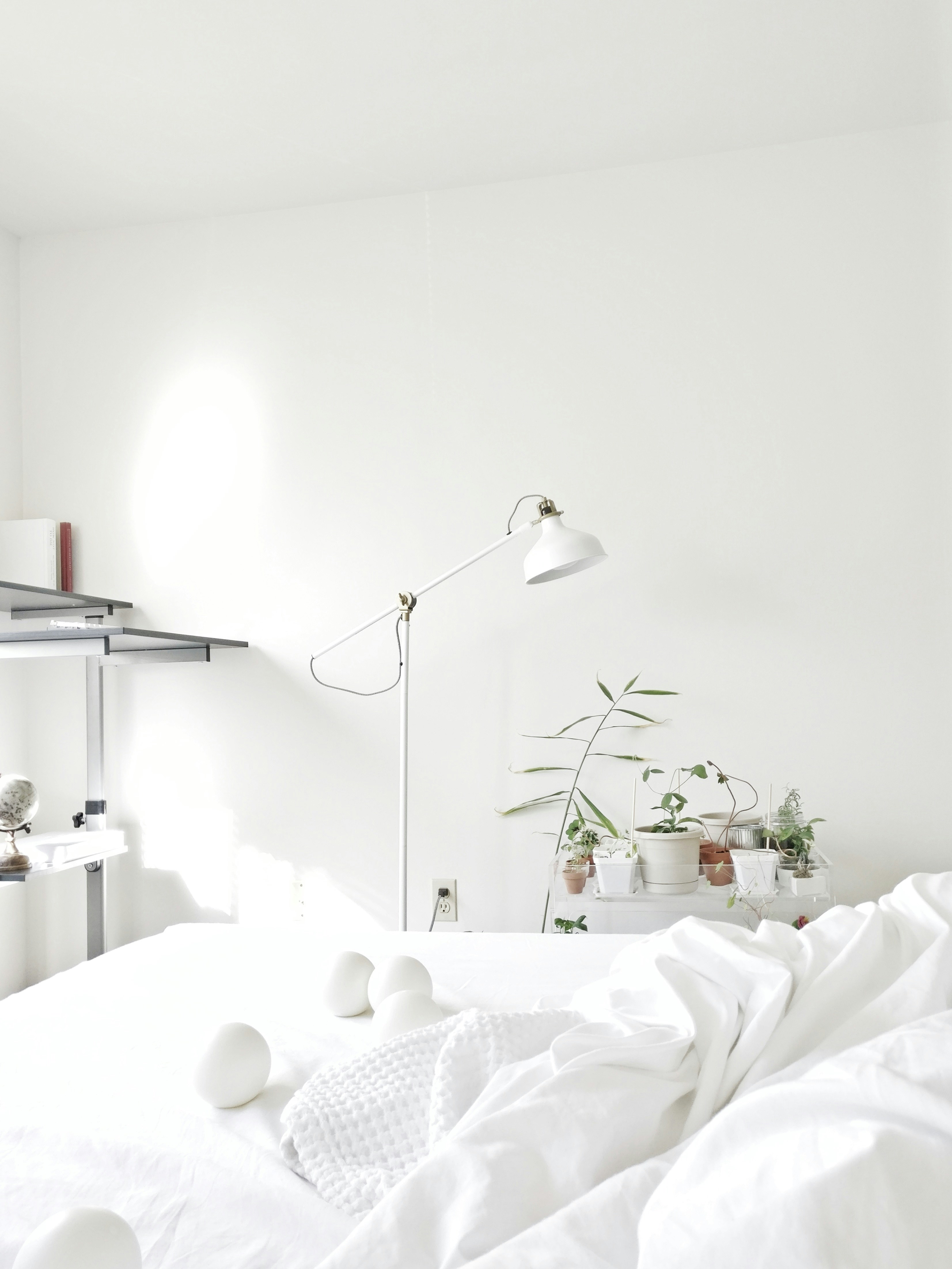 Modern minimalist bedroom interior shot from a straight-on angle highlighting symmetrical bedside lamps and crisp white linen
