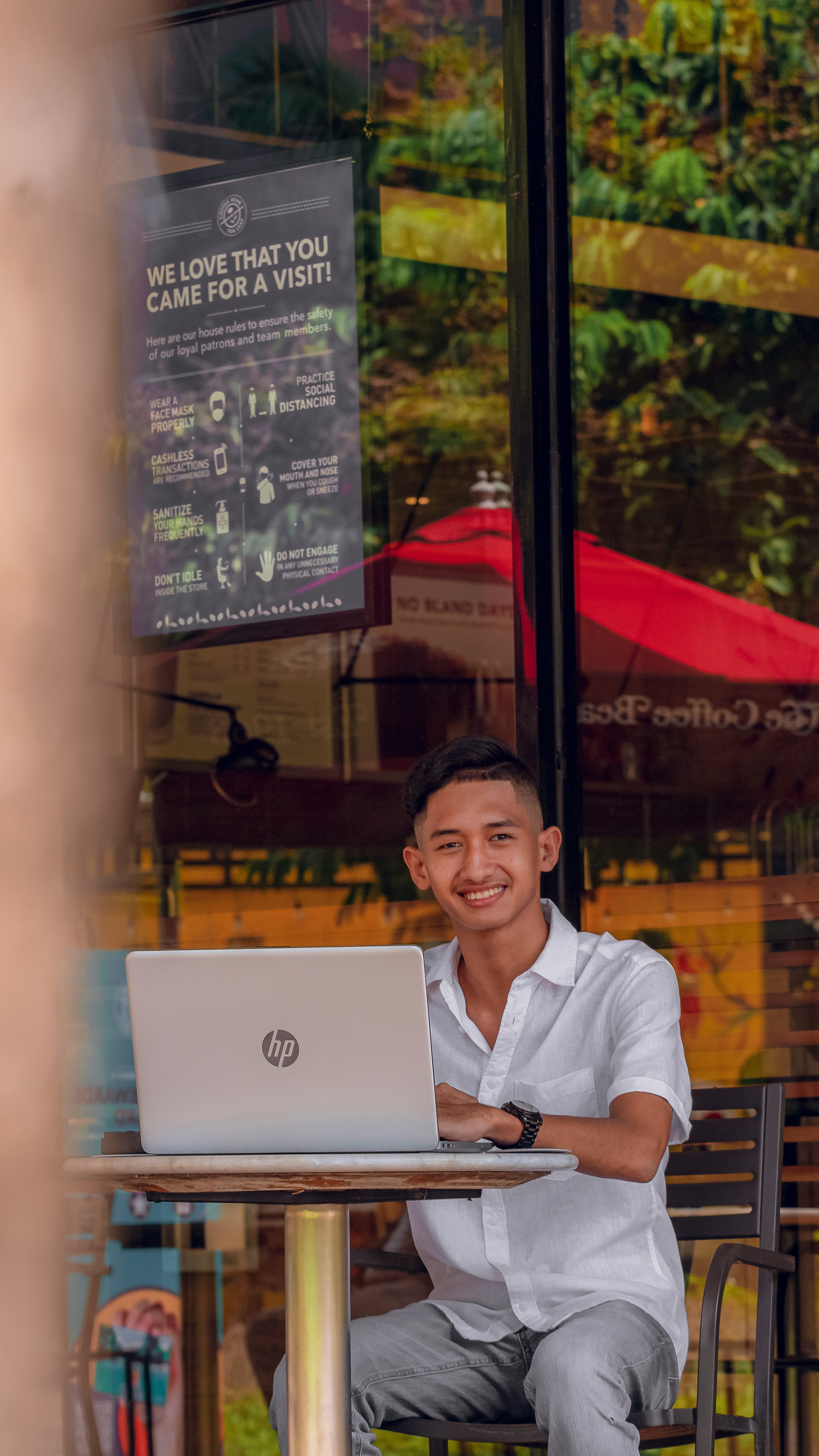 Entrepreneur smiling while looking at laptop with a satisfied expression in a modern office