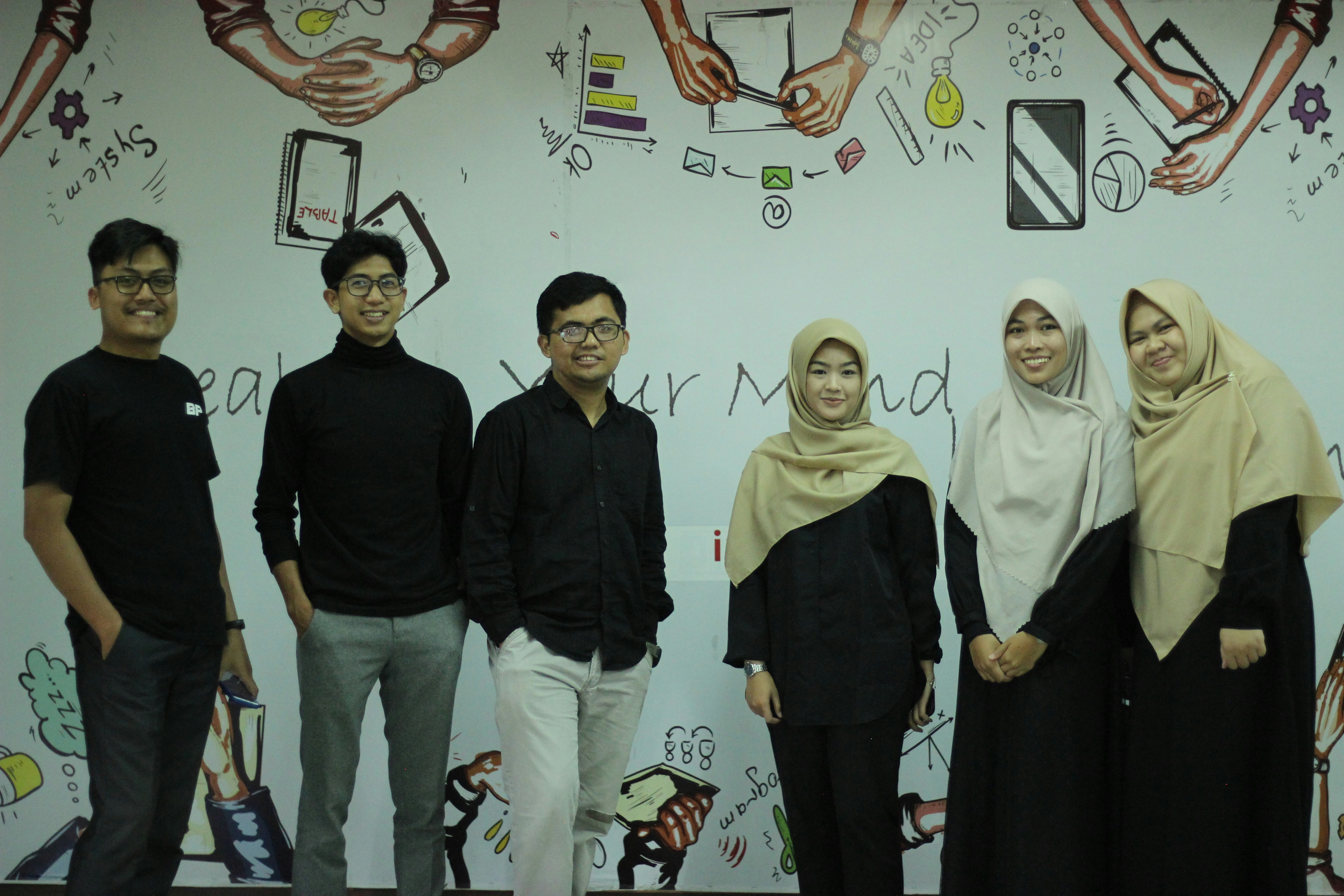 Young creative team collaborating around a laptop celebrating a website launch