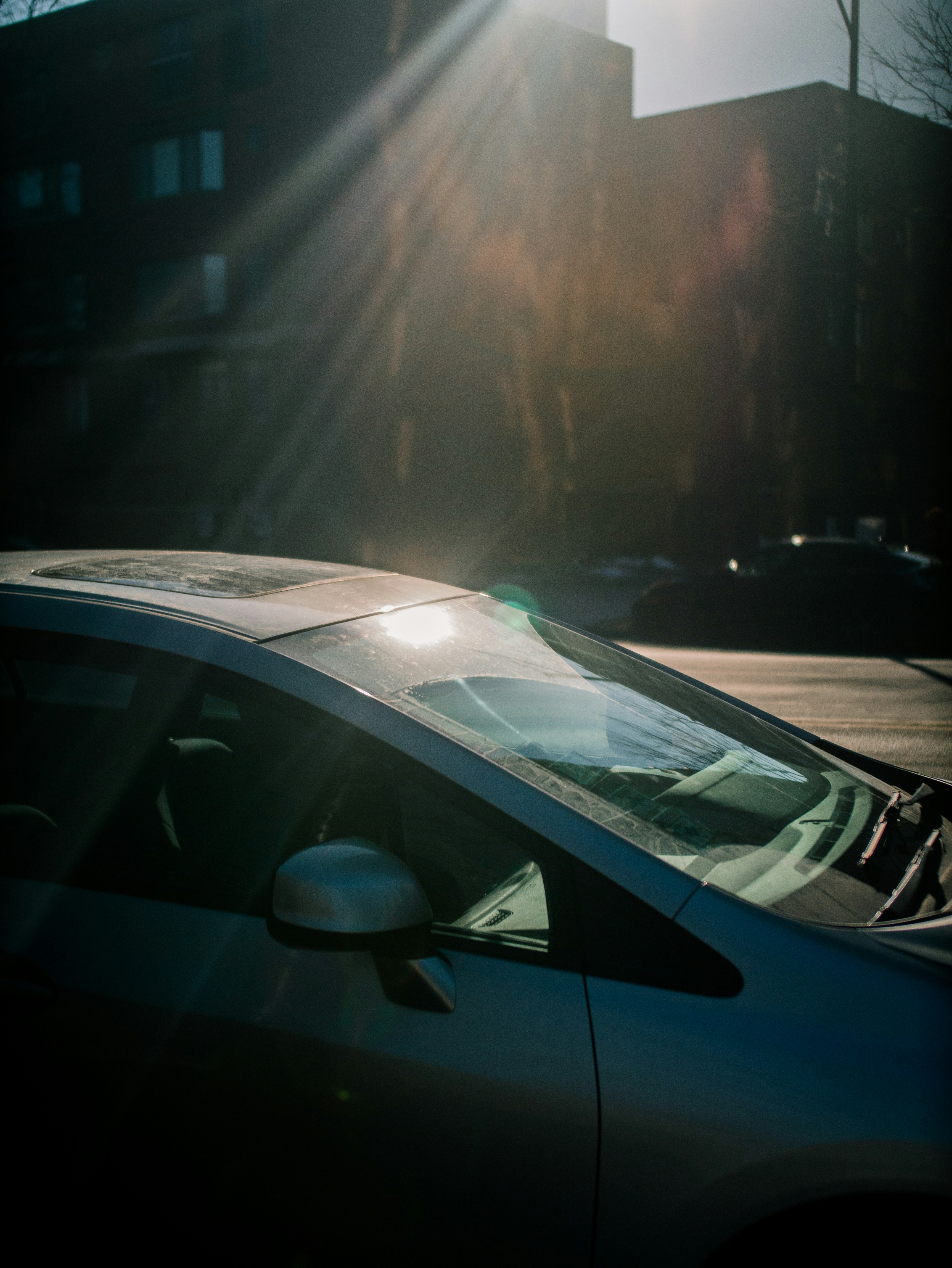 Close up artistic shot of a car parked with focus on the headlight, high contrast, unsplash style