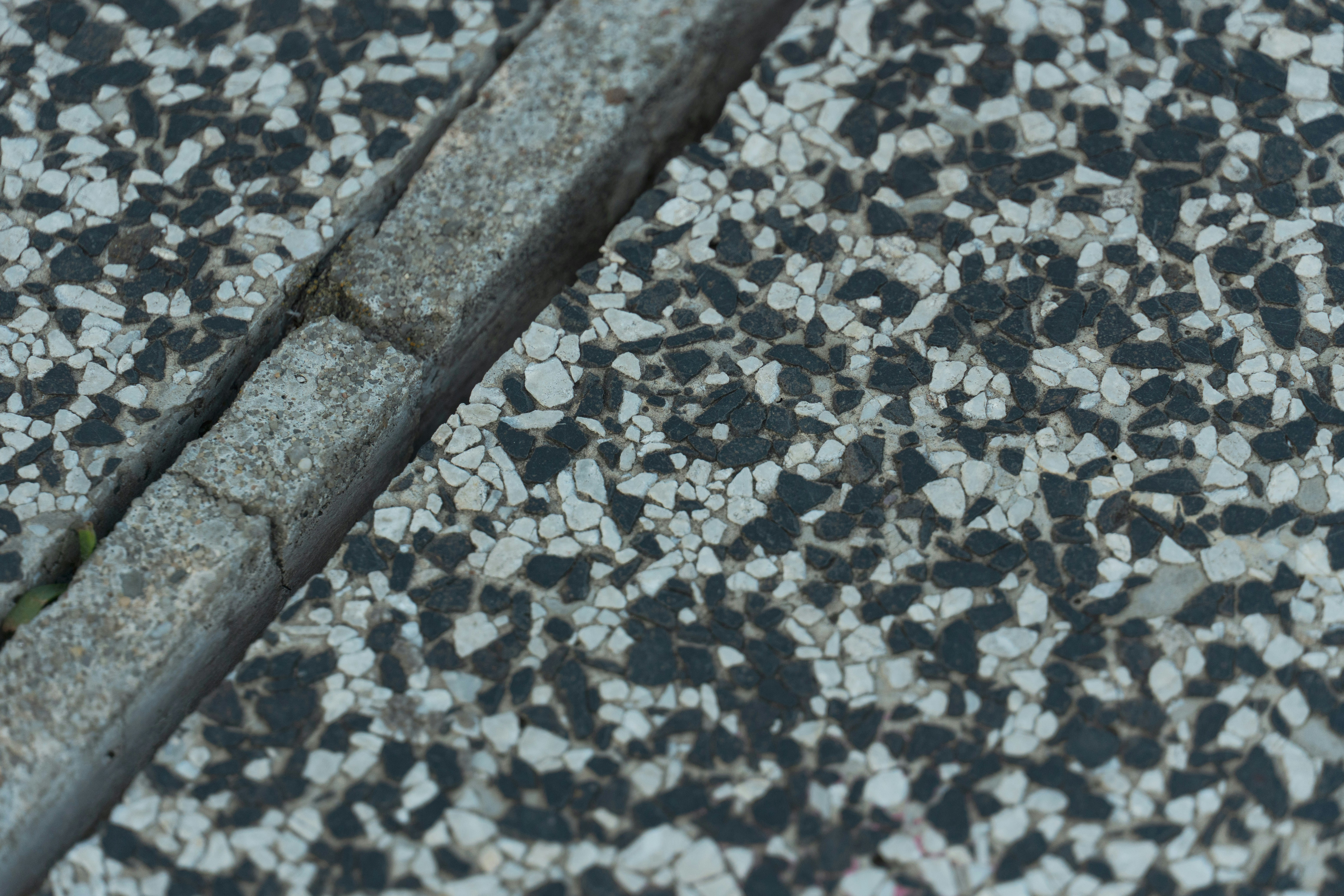 Gros plan comparant la texture du granite poli, du granite à finition cuir et du marbre bouchardé dans un showroom.