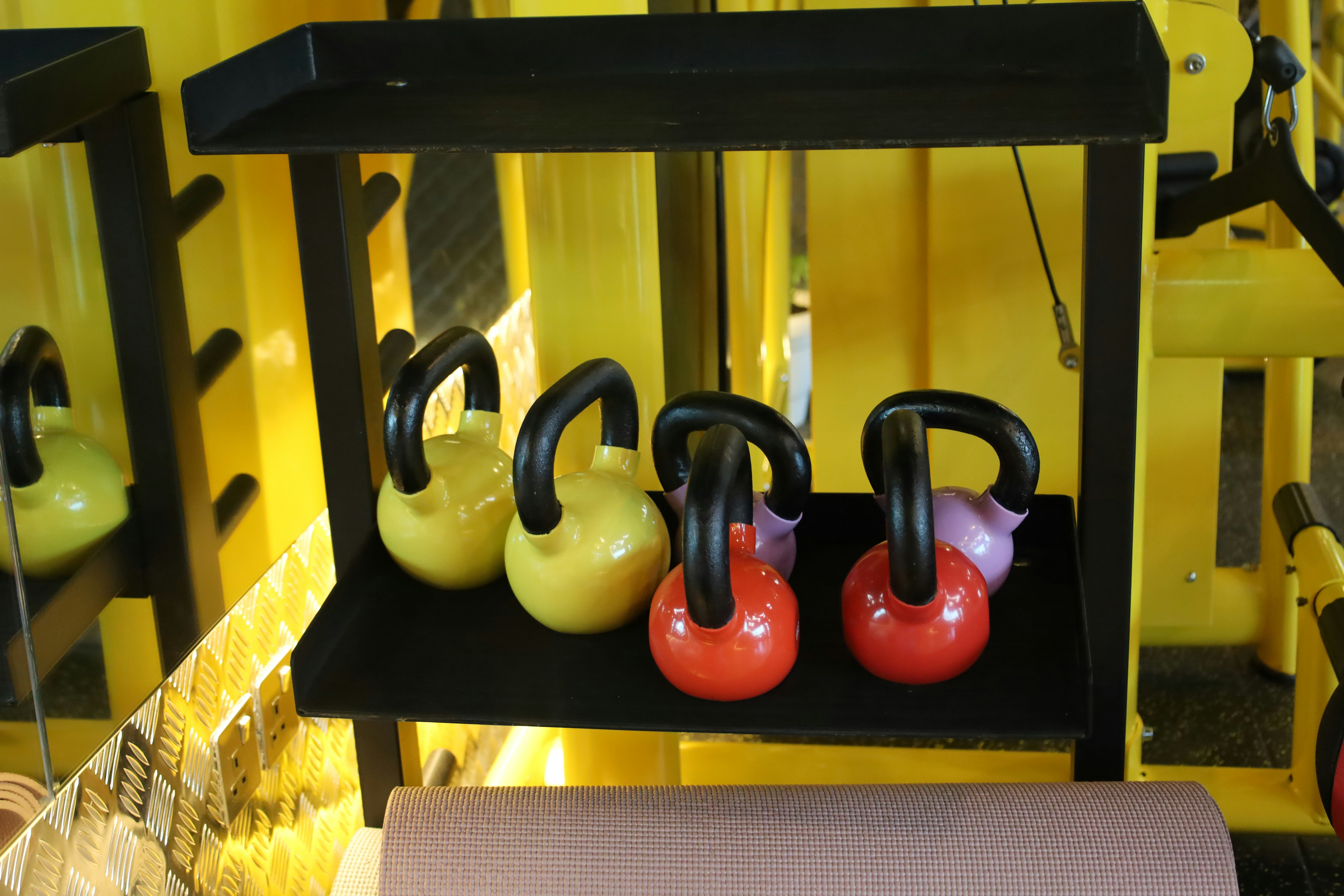 Close up photo of a kettlebell and a towel in a modern, dark themed gym
