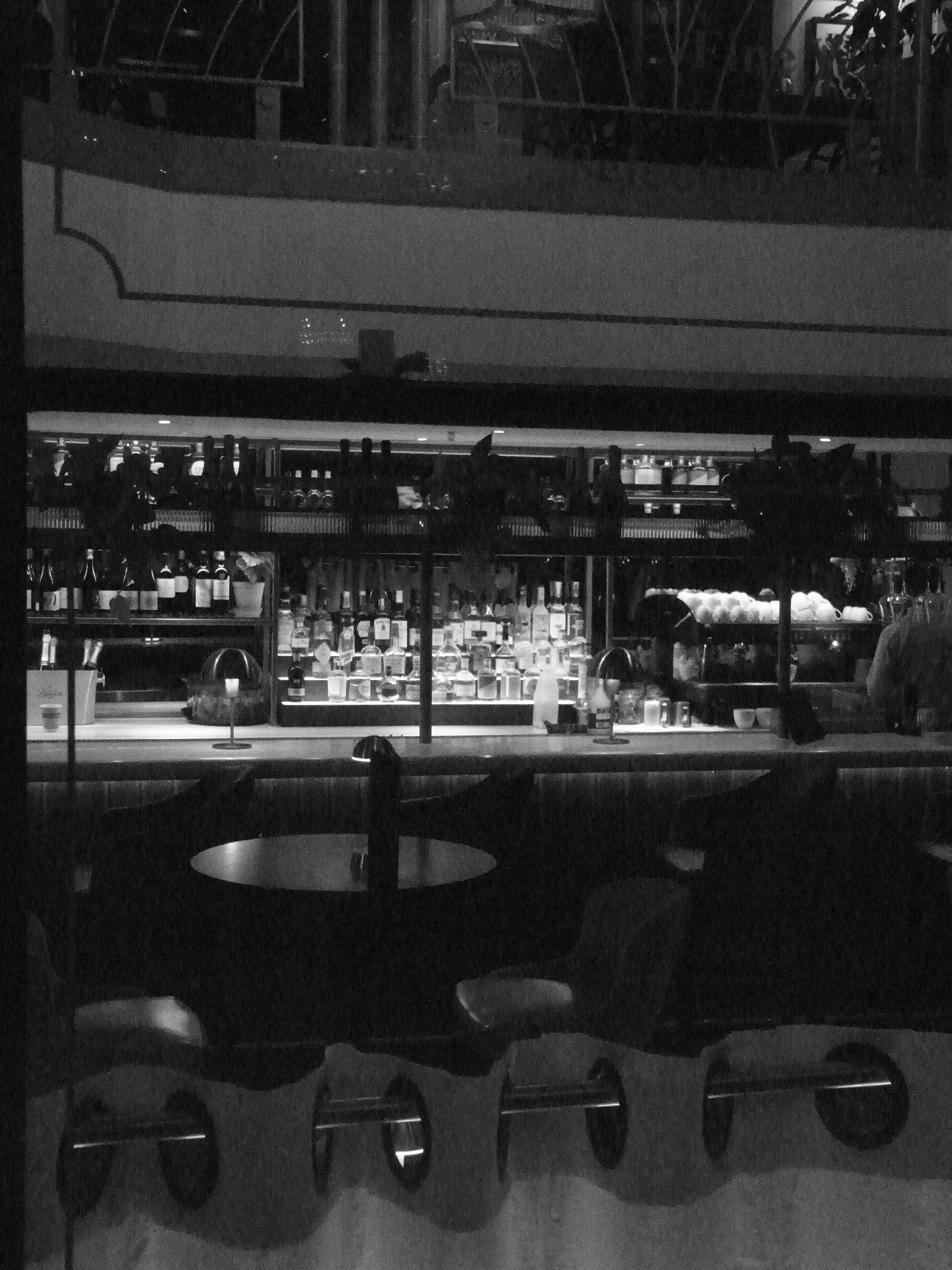 Groupe d'amis discutant joyeusement sur une terrasse de pub le soir avec des boissons