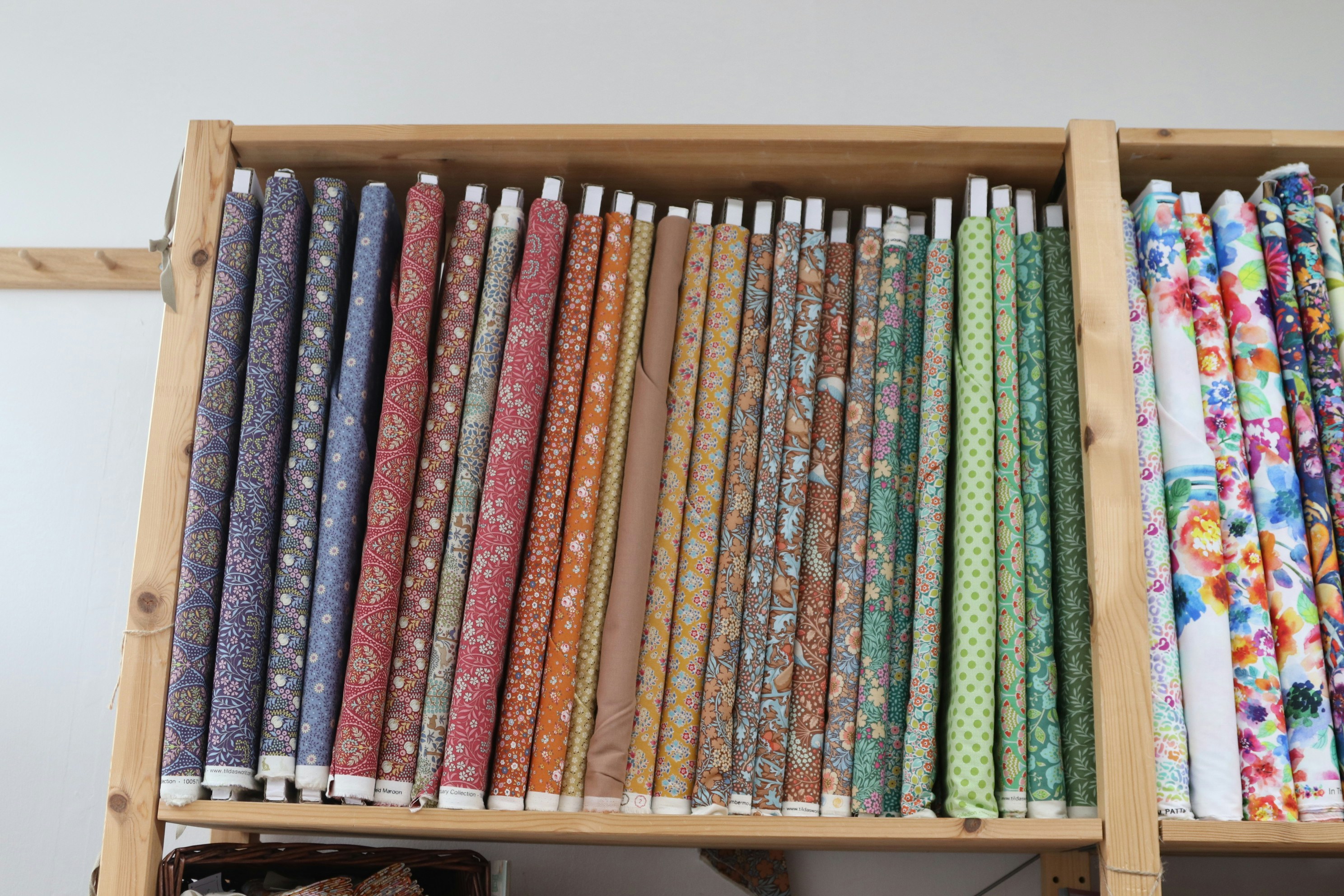 Minimalist moodboard on a cork wall with fabric samples, color swatches and opened design books