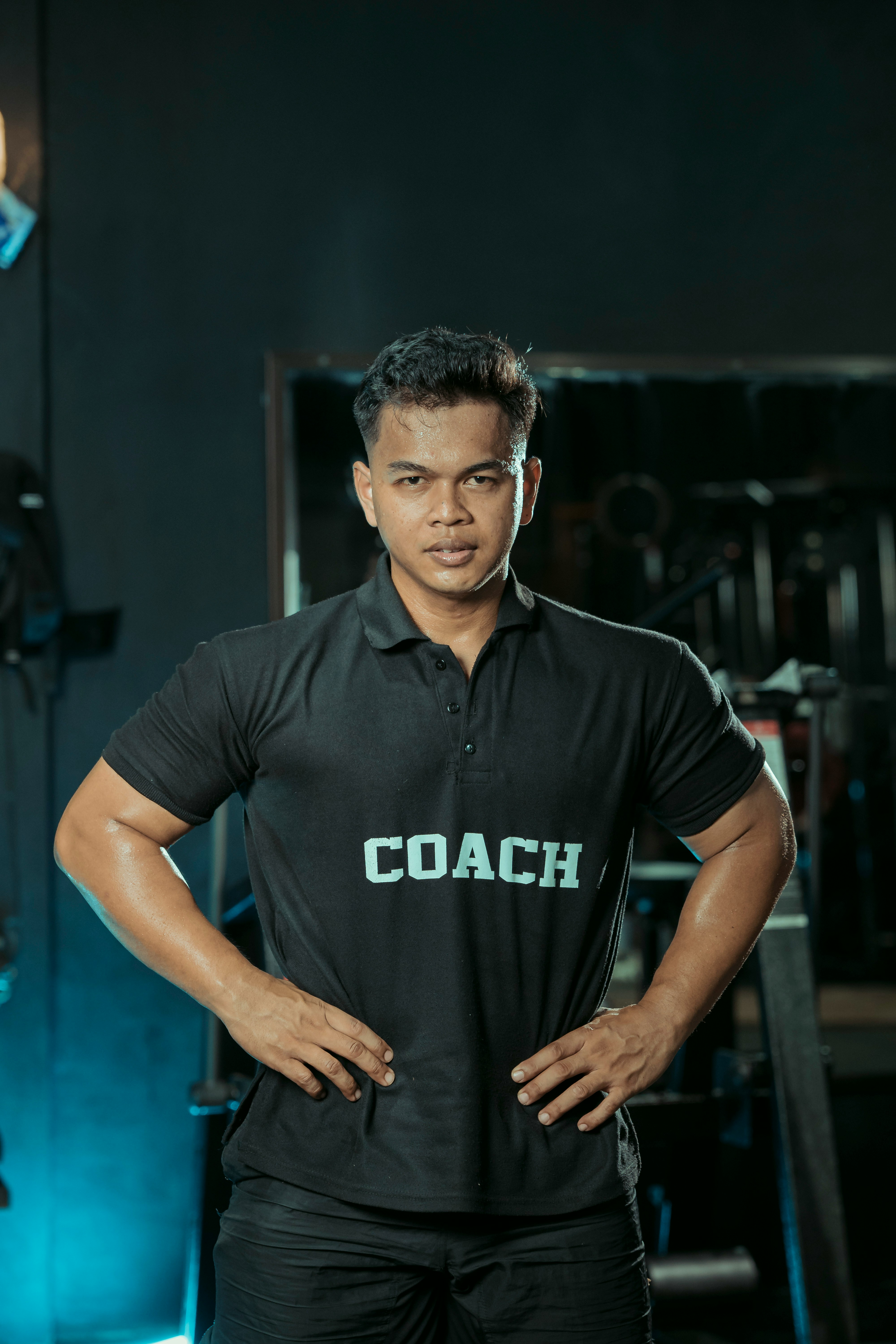 A professional coach adjusting weights for a client in a private gym setting, focusing on form and technique.