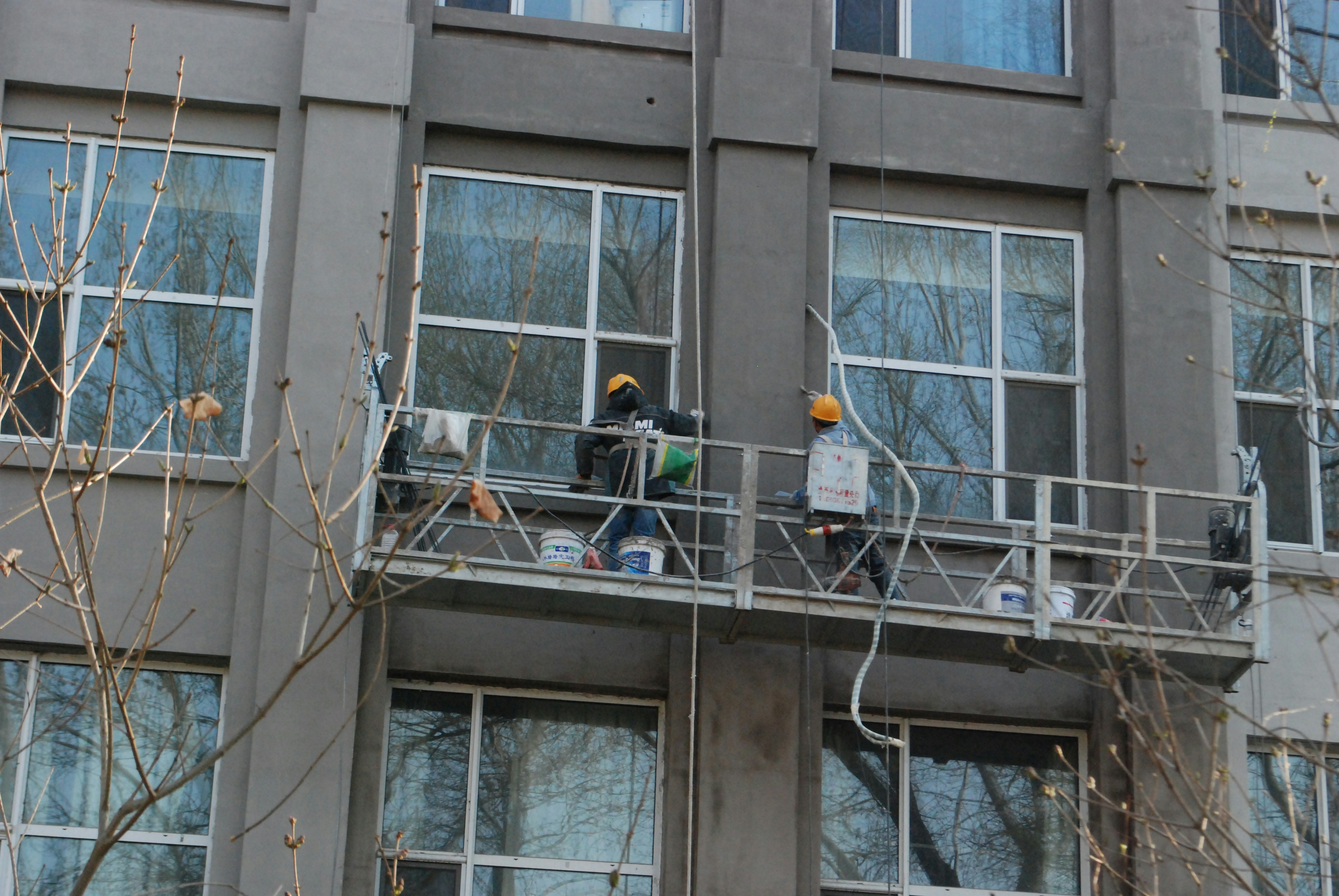 Worker installing triple glazed windows in a renovation project, focus on the tools and precision