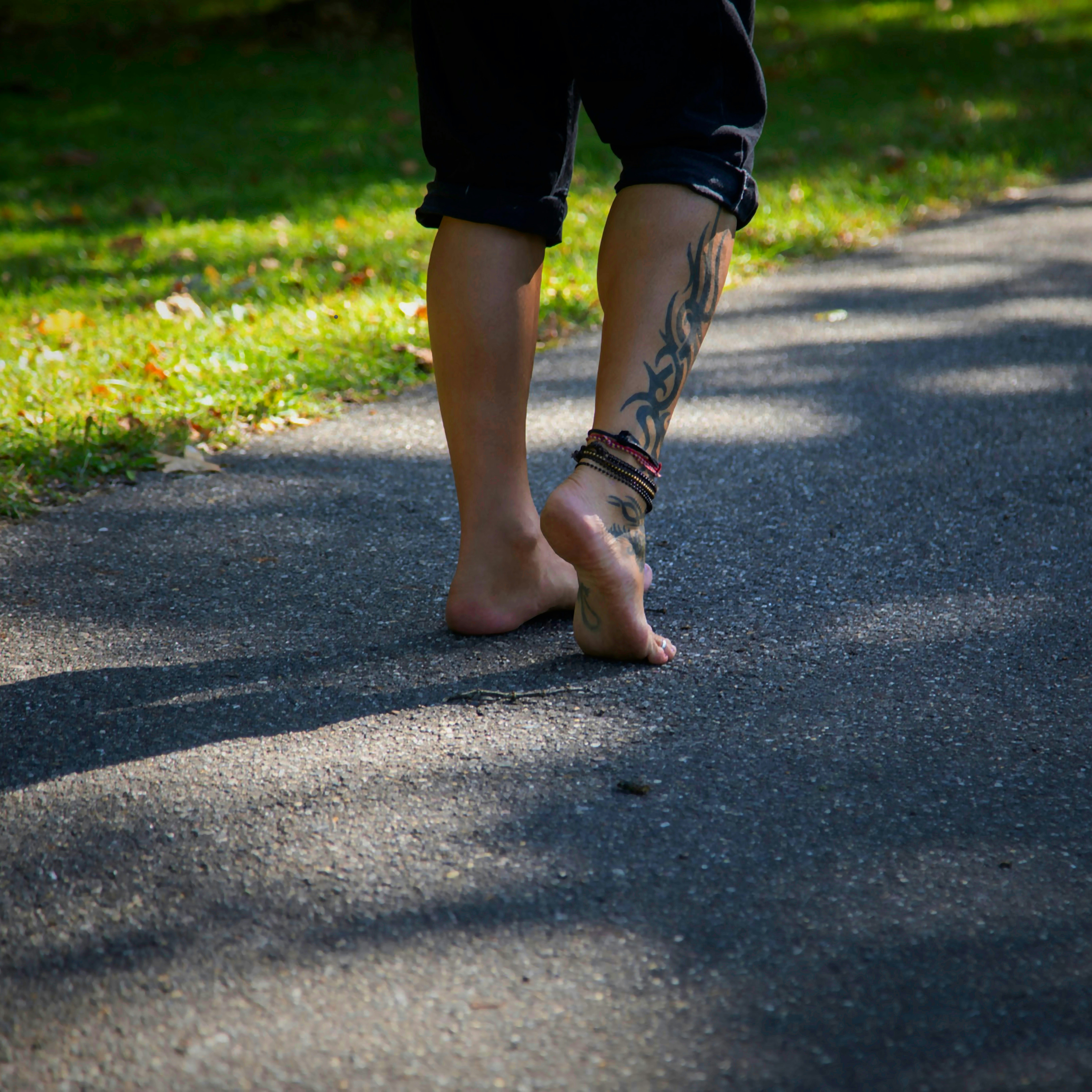 Man tying running shoes getting ready for a workout outdoors in a park
