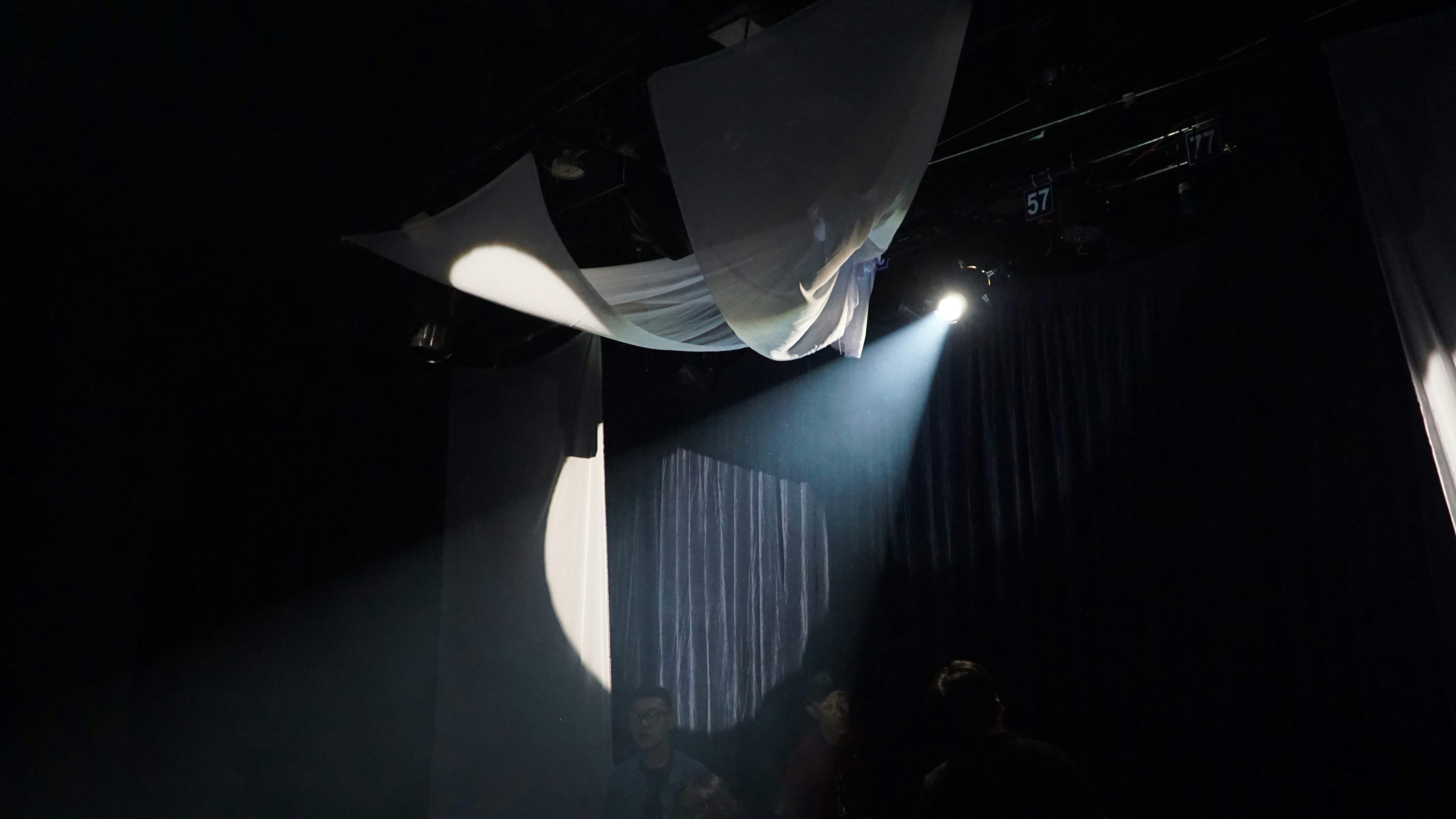 An abstract, artistic image representing experimental theater with dramatic lighting and movement.