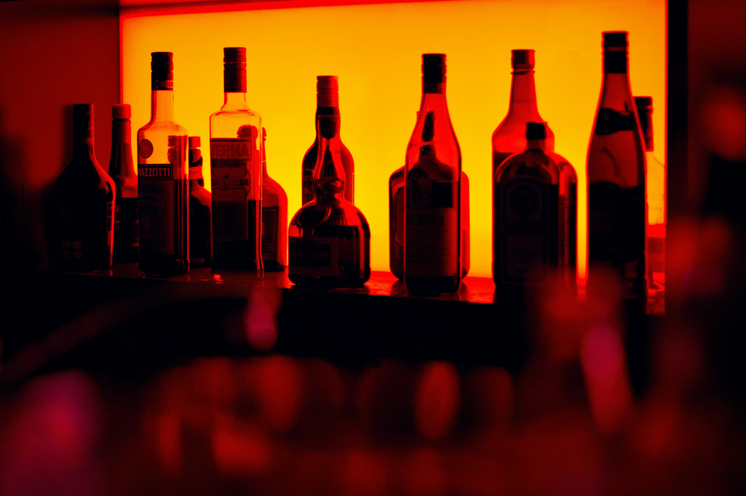 Close up of diverse non-alcoholic bottles and glasses on a luxury wooden hotel bar counter