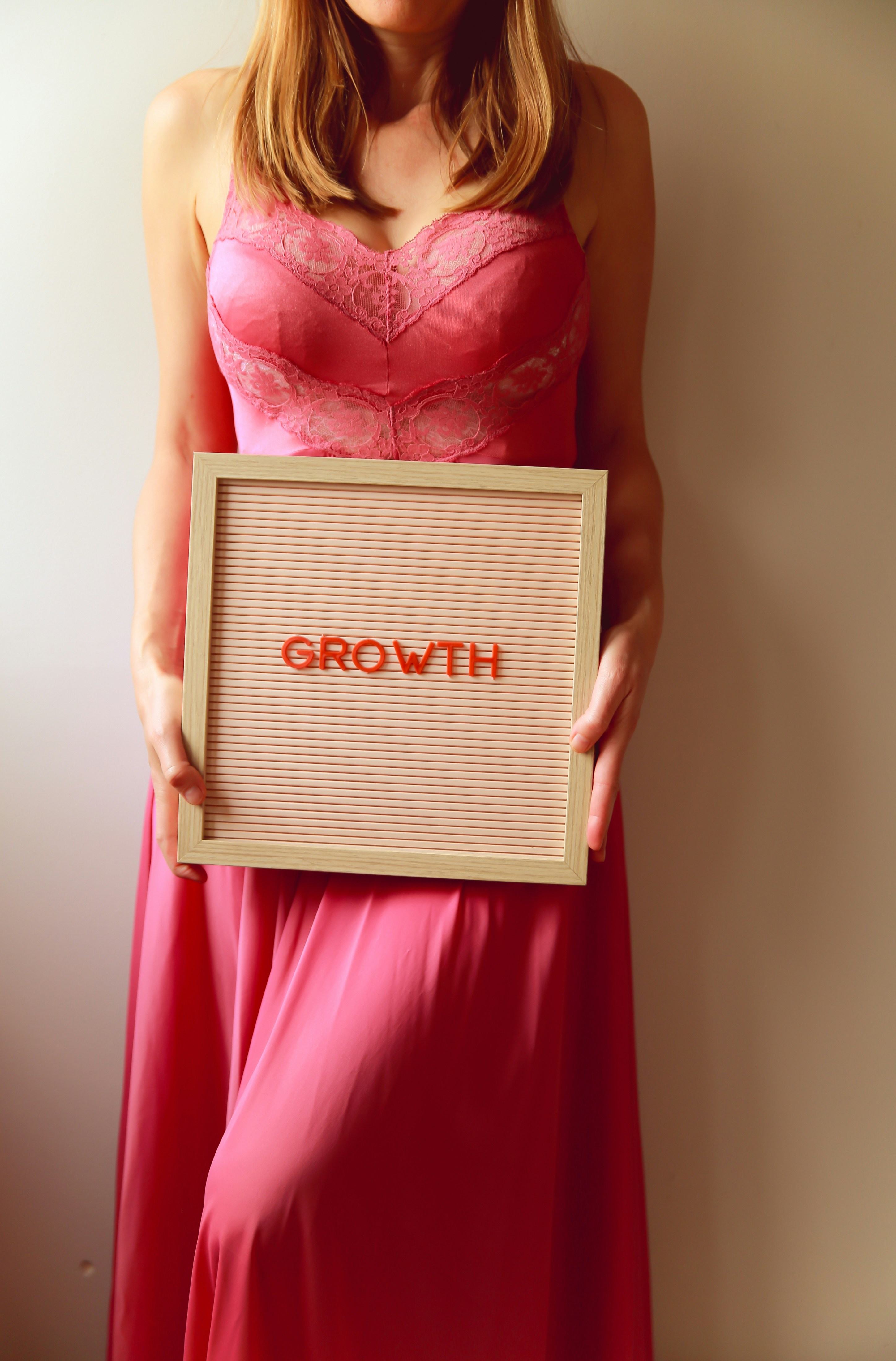 Business woman presenting a growth chart on a whiteboard to her colleagues in a meeting room.