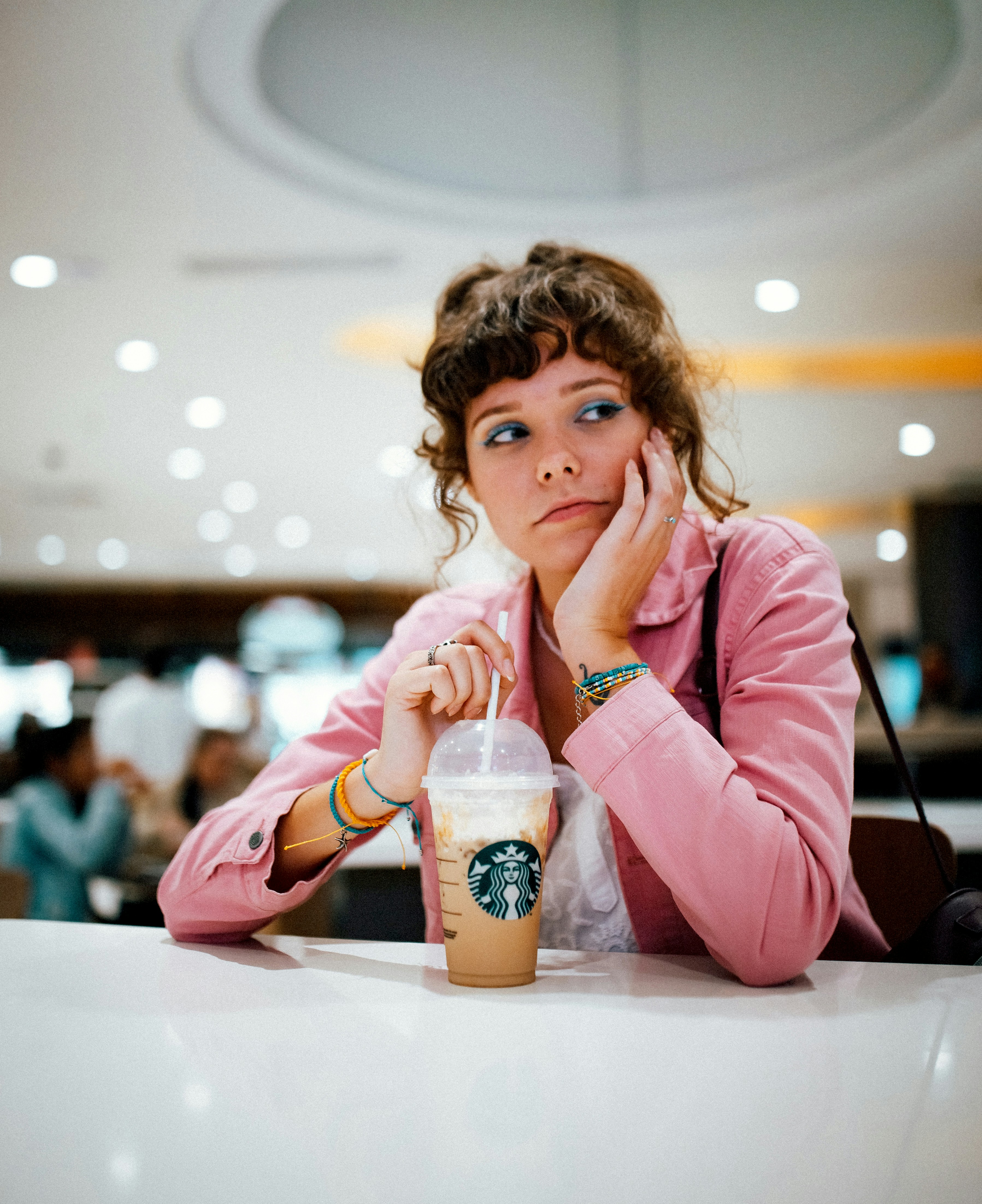 Young woman using a smartphone in a shopping mall, looking at a digital map application
