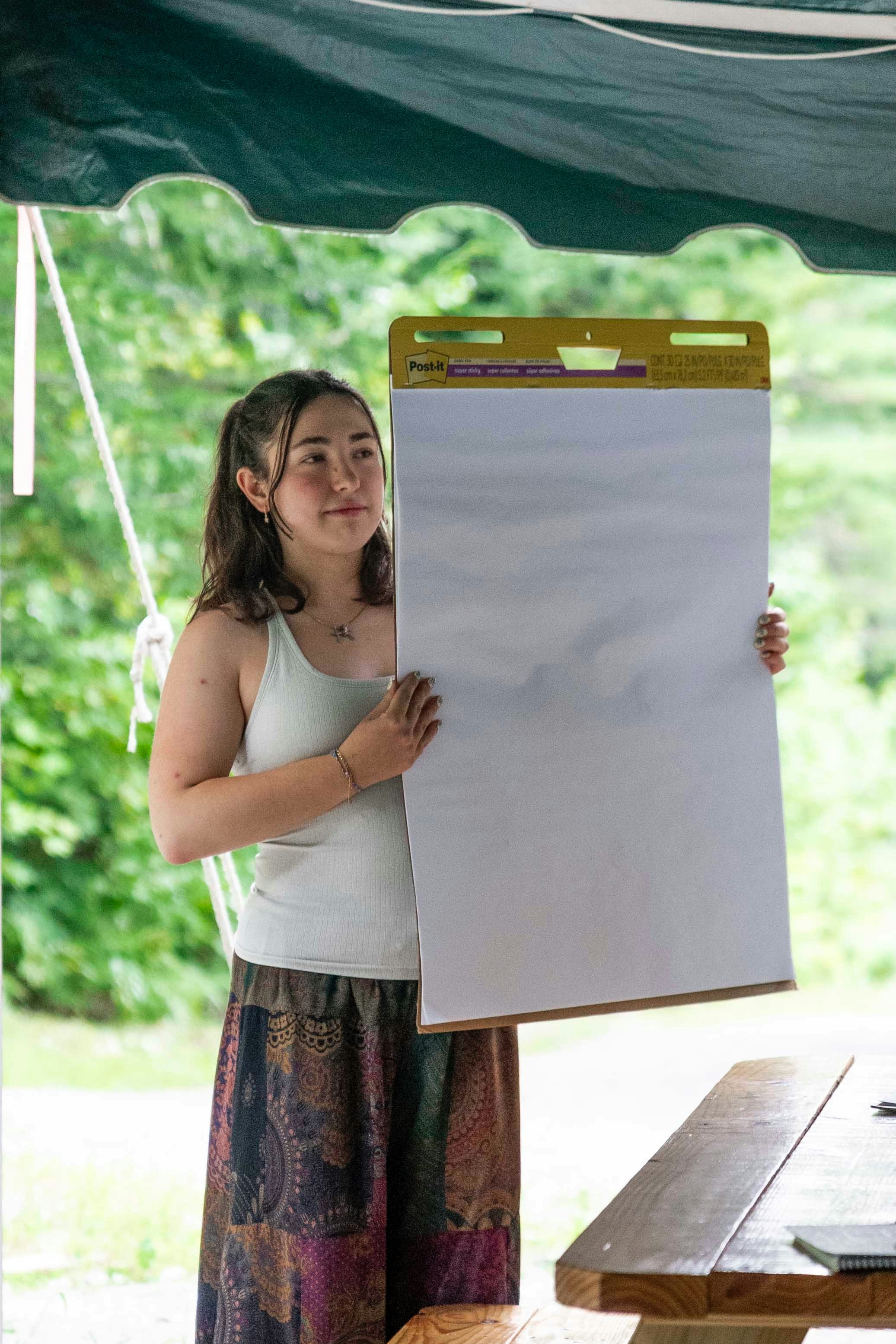 Woman presenting data on a whiteboard to colleagues