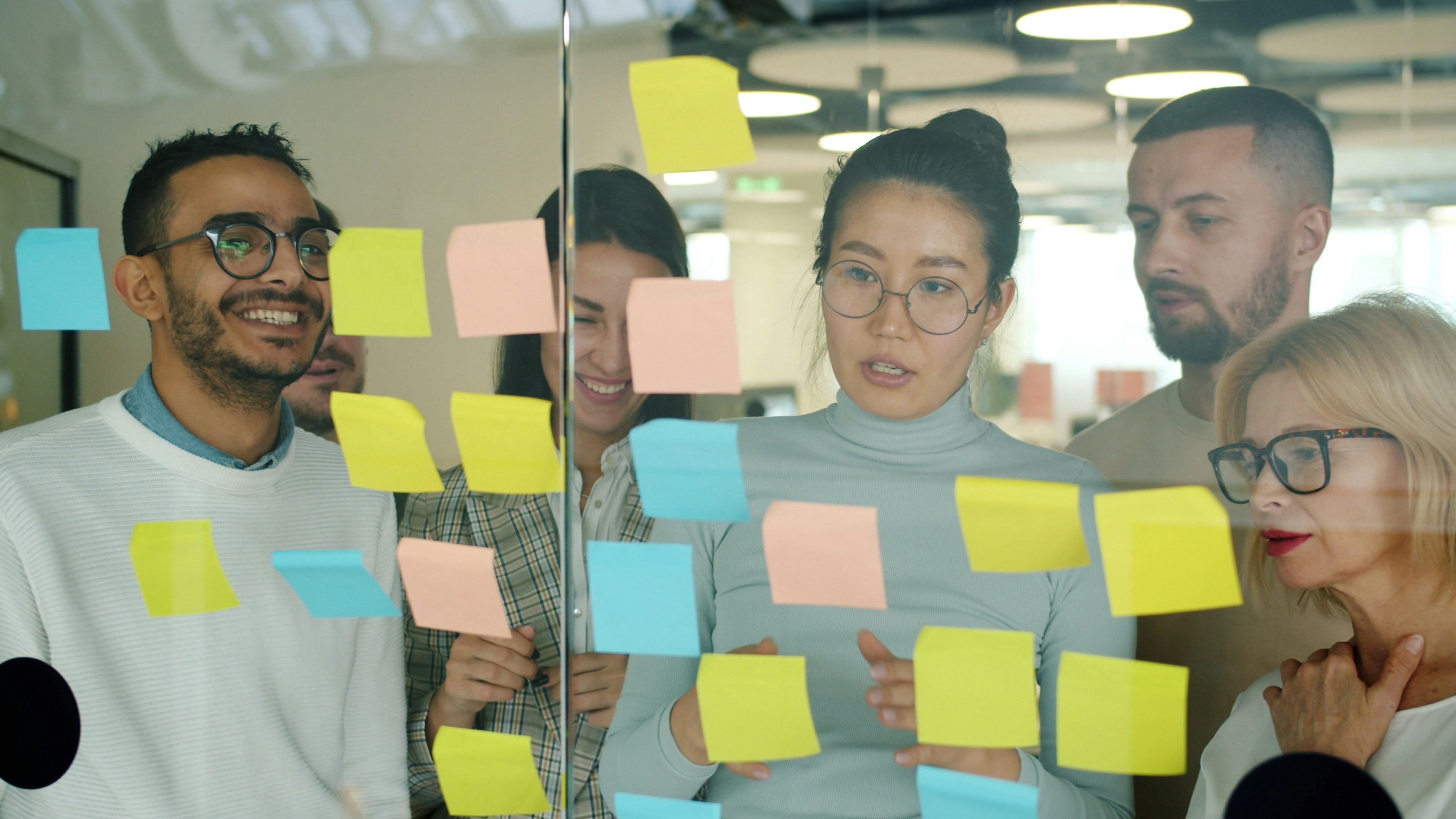 Business brainstorming session with sticky notes in a glass room