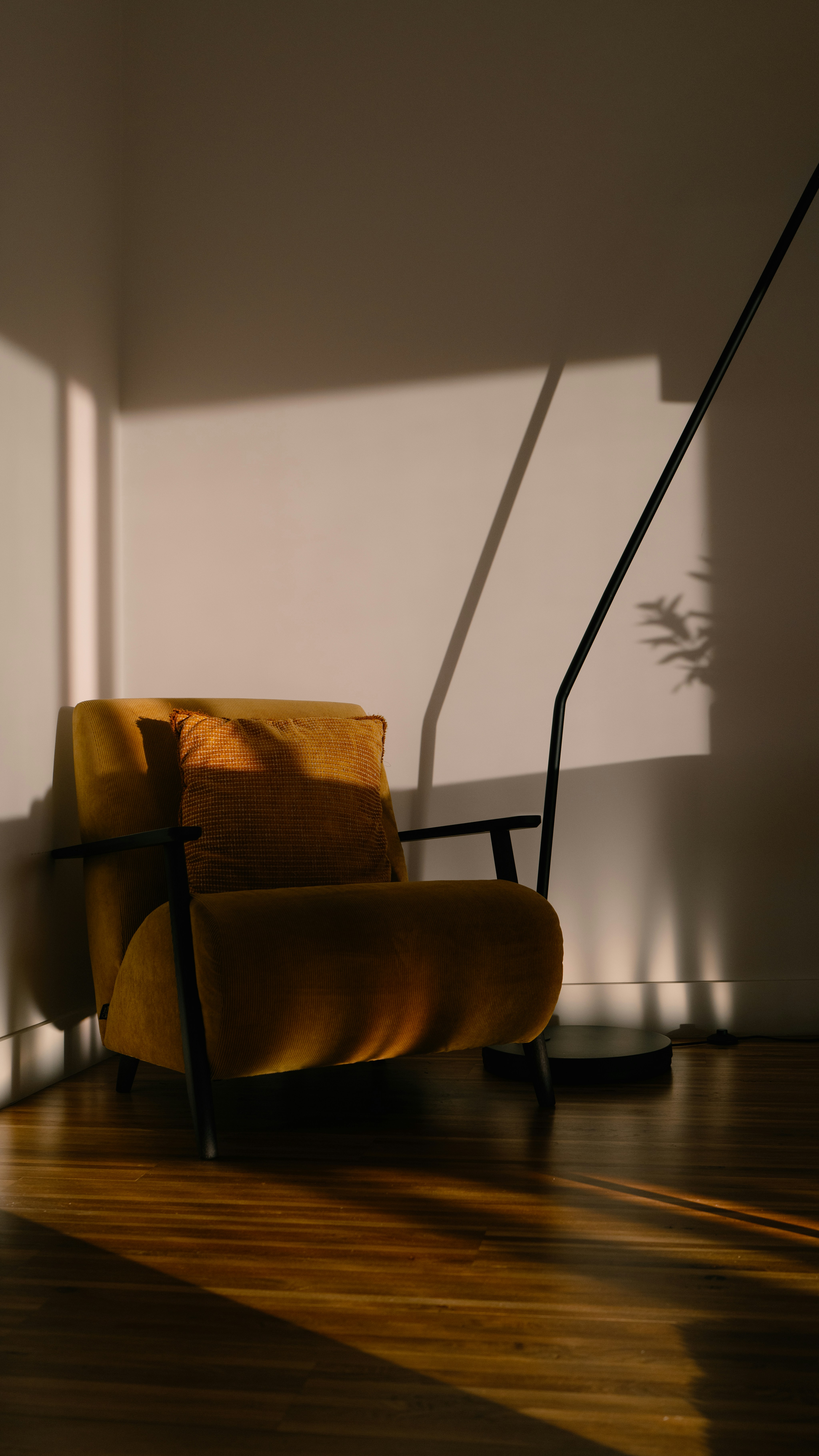 Minimalist floor lamp next to a sleek sofa, emphasizing warm lighting design.