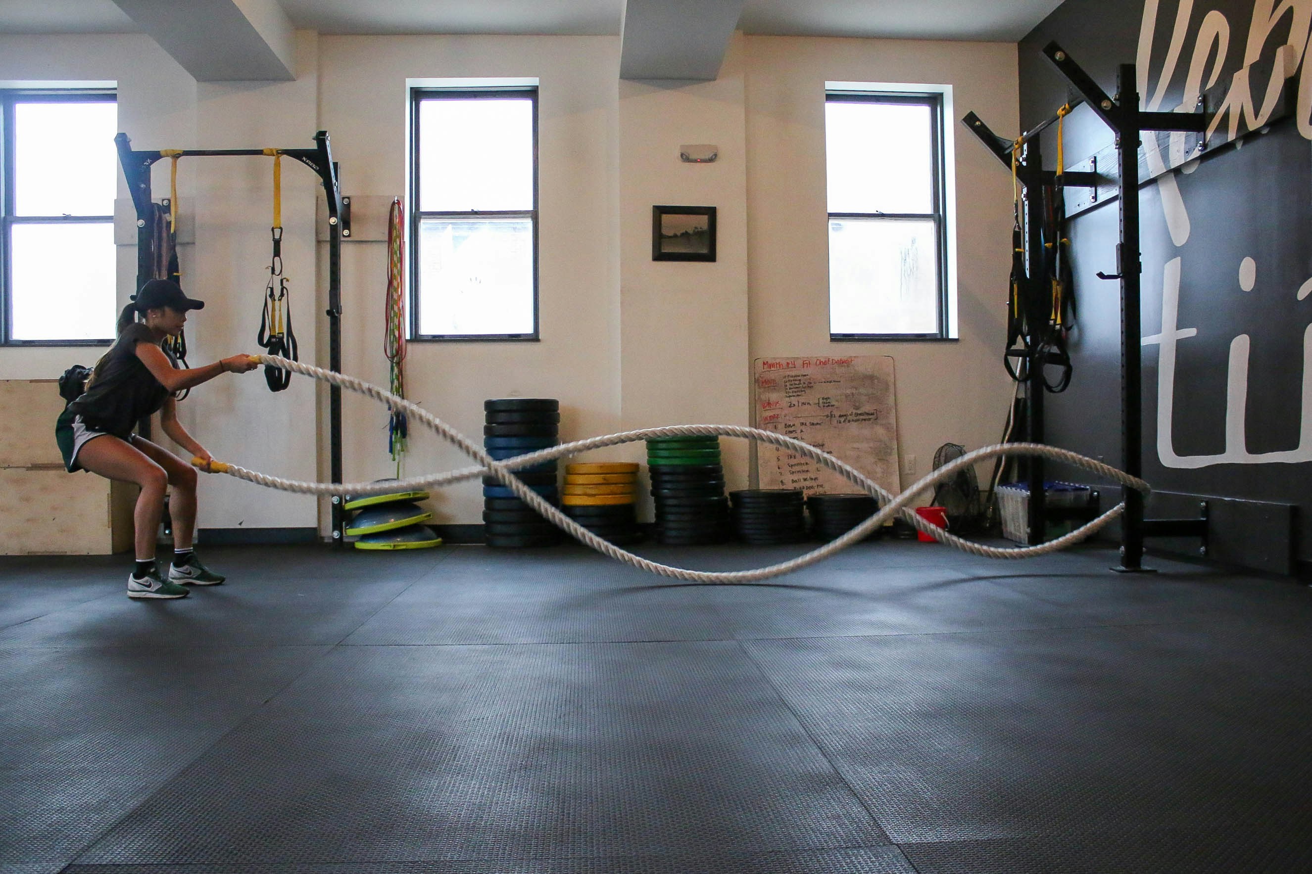 Athletic person doing intense ropes exercise in a private studio setting