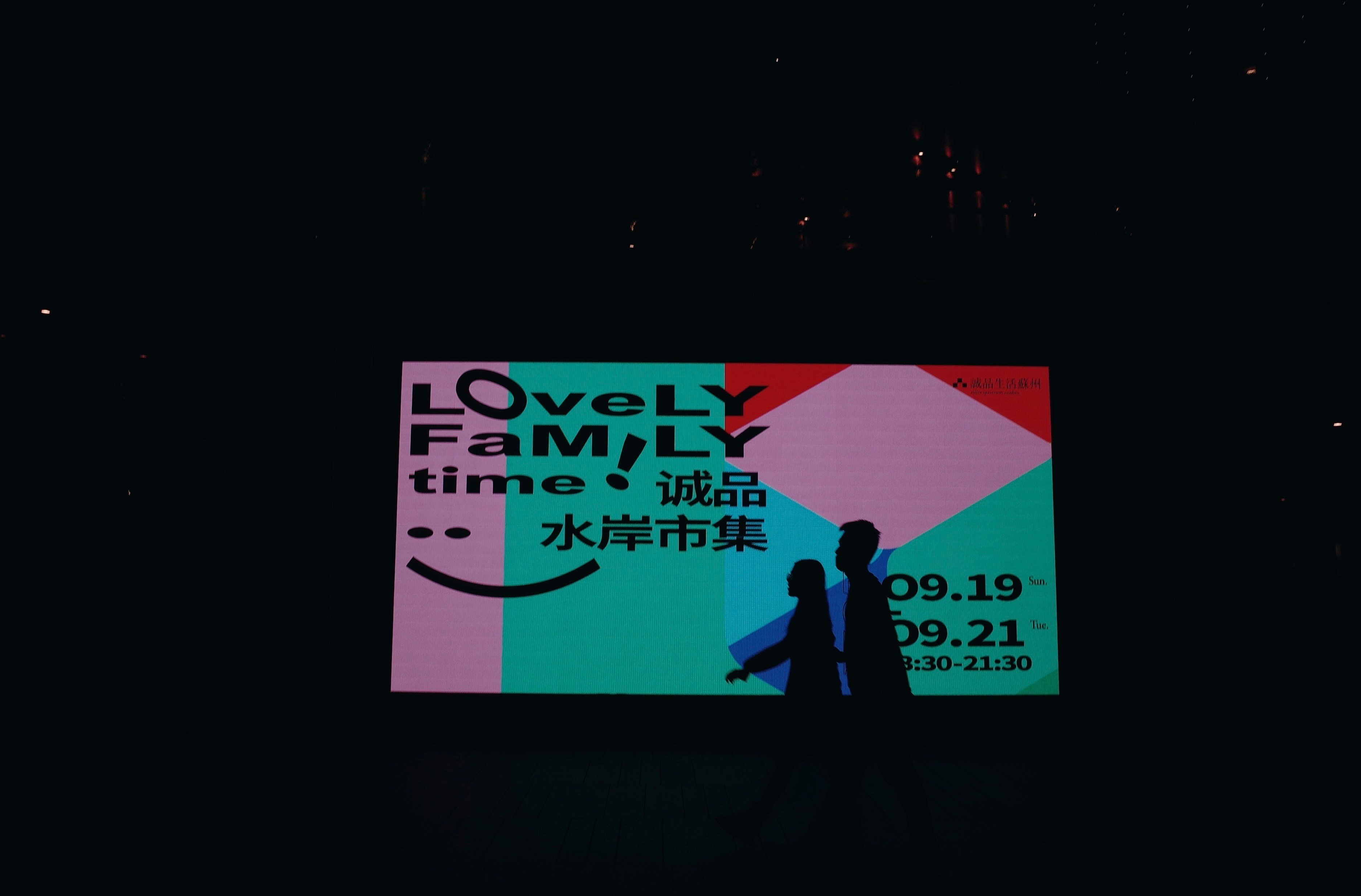A fan holding a smartphone scanning a QR code on a poster at a concert