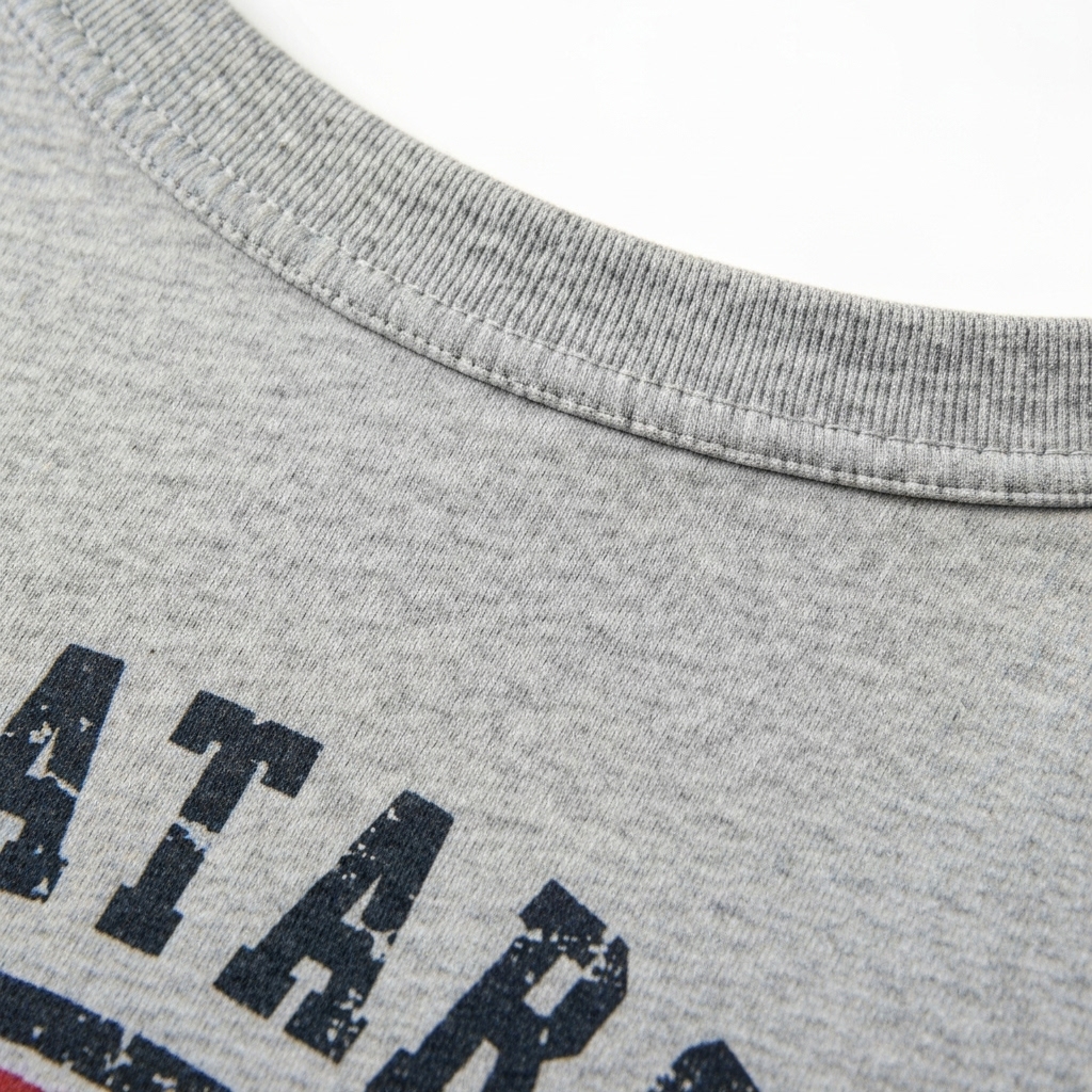 Close-up detail of soft fabric texture on a graphic tee, showing high-quality stitching and vintage print style