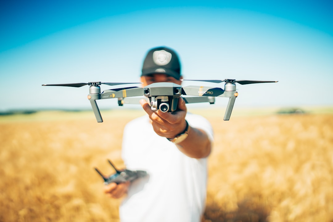 "Pilote de drone professionnel en gilet haute visibilité contrôle son drone dans un ciel bleu clair, tarif formation pilote d