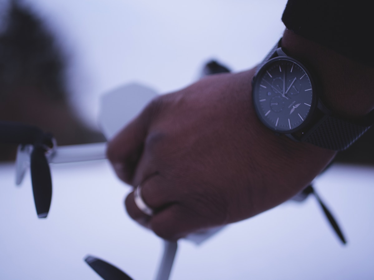 Gros plan d'une main portant une montre noire élégante.