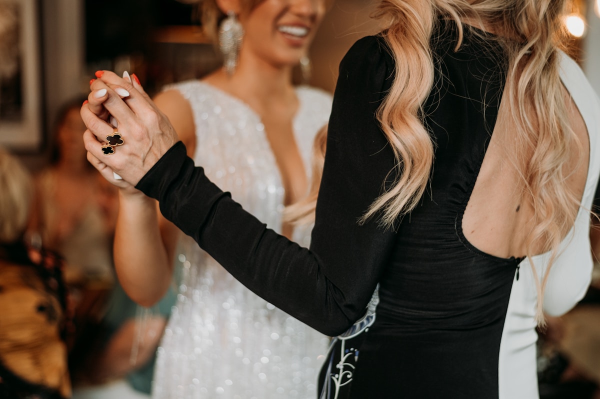 a woman standing next to another woman holding a cigarette