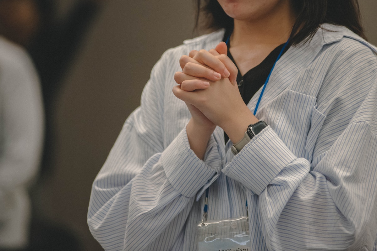 A person clasps hands together in prayer.