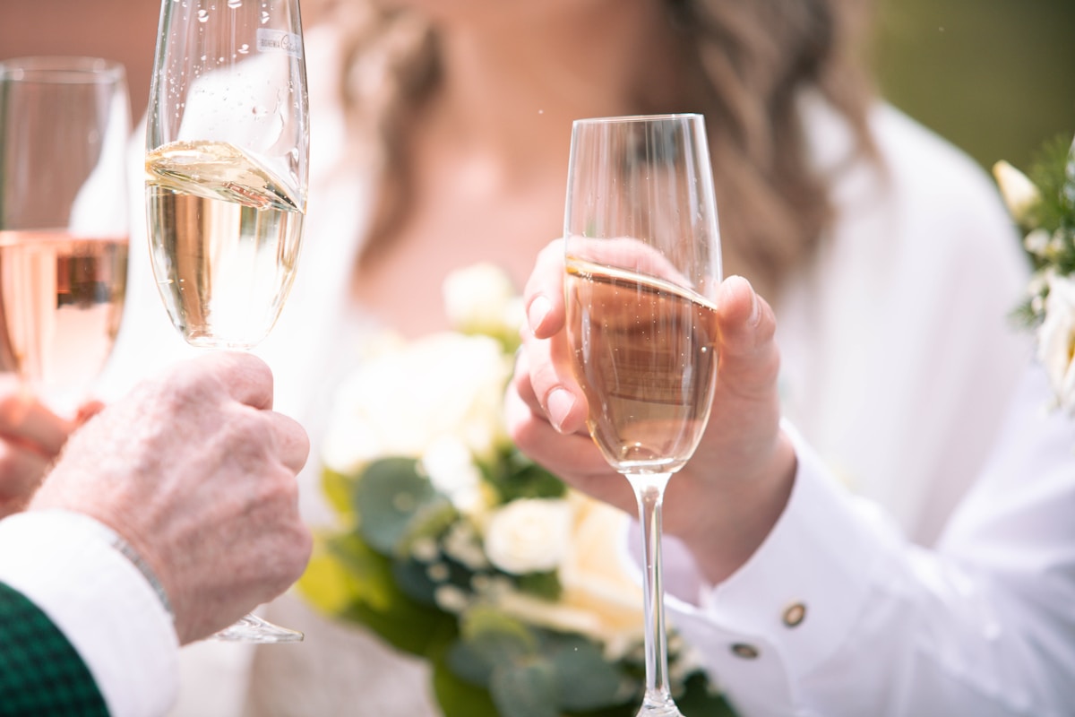 Deux coupes de champagne dans les mains d'un couple lors d'un événement festif.