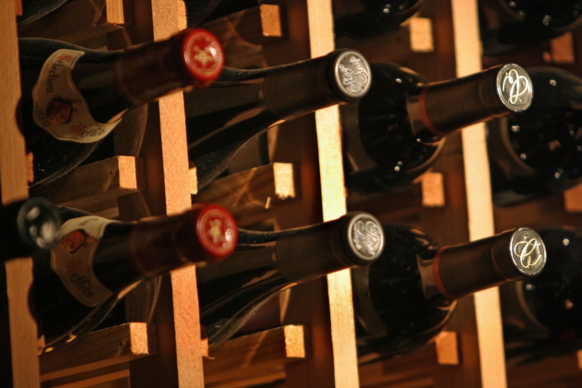 Bouteilles de vin rangées sur une étagère en bois.