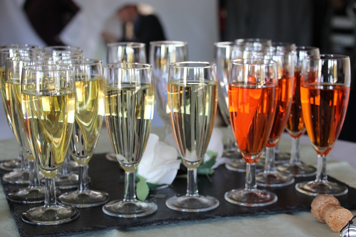 Verres de champagne et cocktails colorés sur une table sombre.