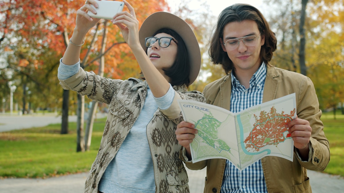 Deux touristes explorant la ville avec une carte et un téléphone.