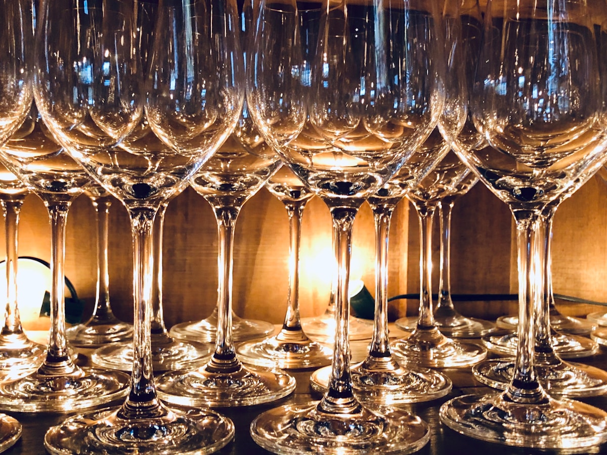 Verres de vin cristallins brillants alignés sur une surface sombre.