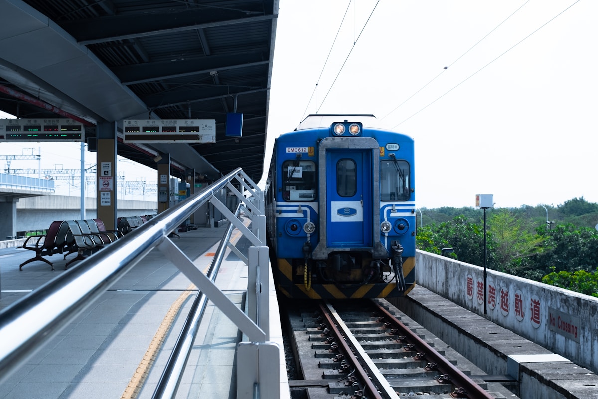 Train bleu sur la voie ferrée dans une gare.