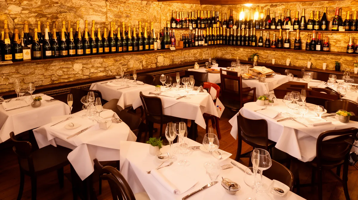 Salle de restaurant élégante avec étagères de bouteilles de vin.