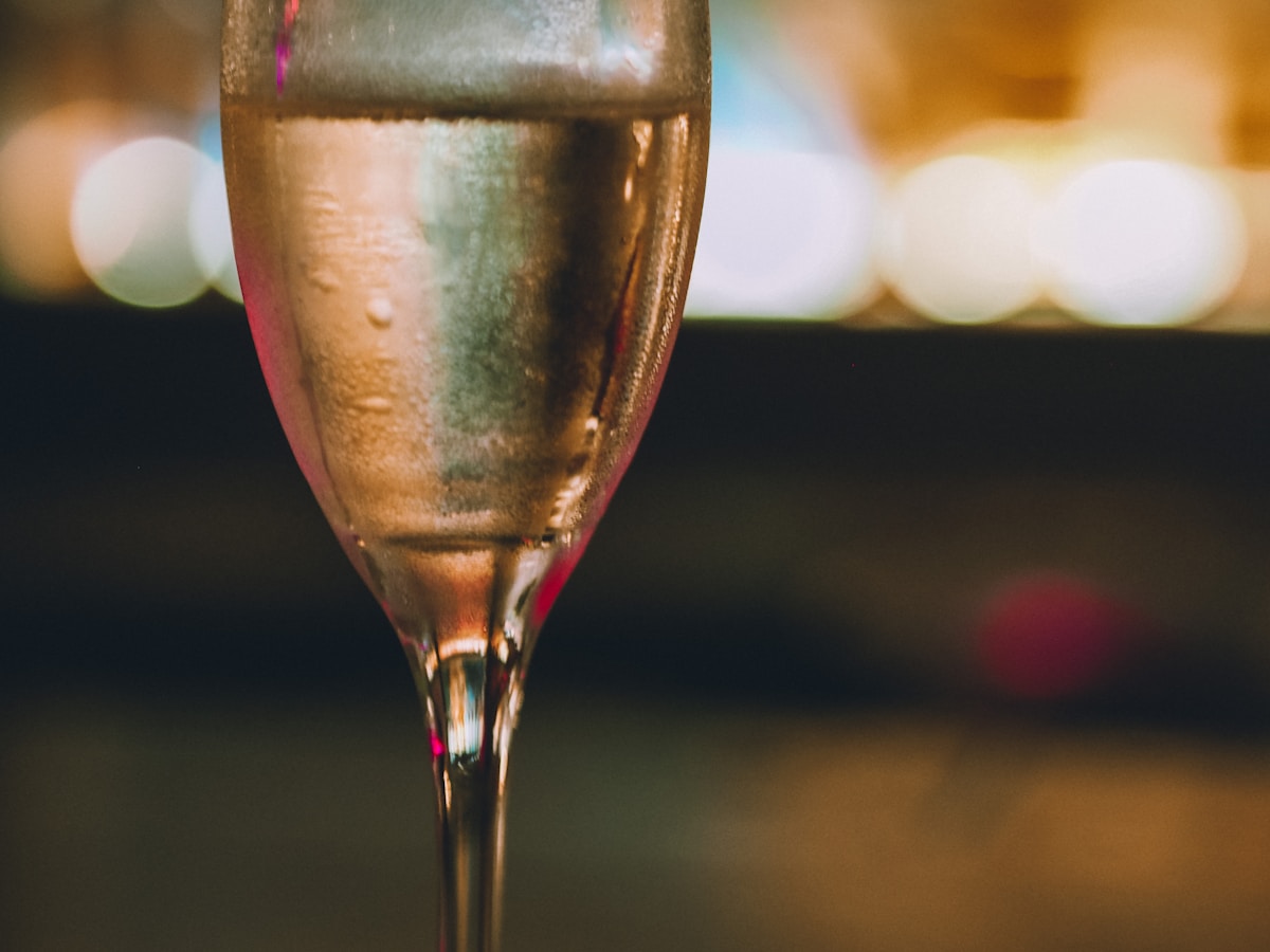 Verre de champagne avec des bulles scintillantes et un arrière-plan flou.