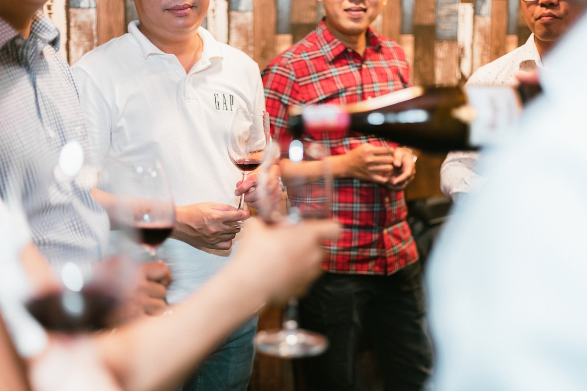 Groupe d'amis dégustant du vin dans un bar rustique.