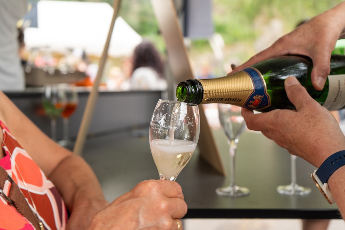 Versage de champagne dans un verre à pied sur une table.
