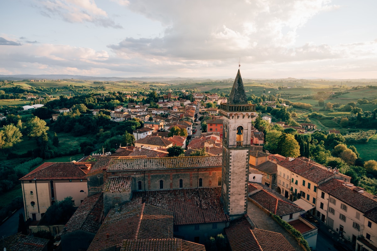 Paysage pittoresque d'un village médiéval italien avec une tour élancée.