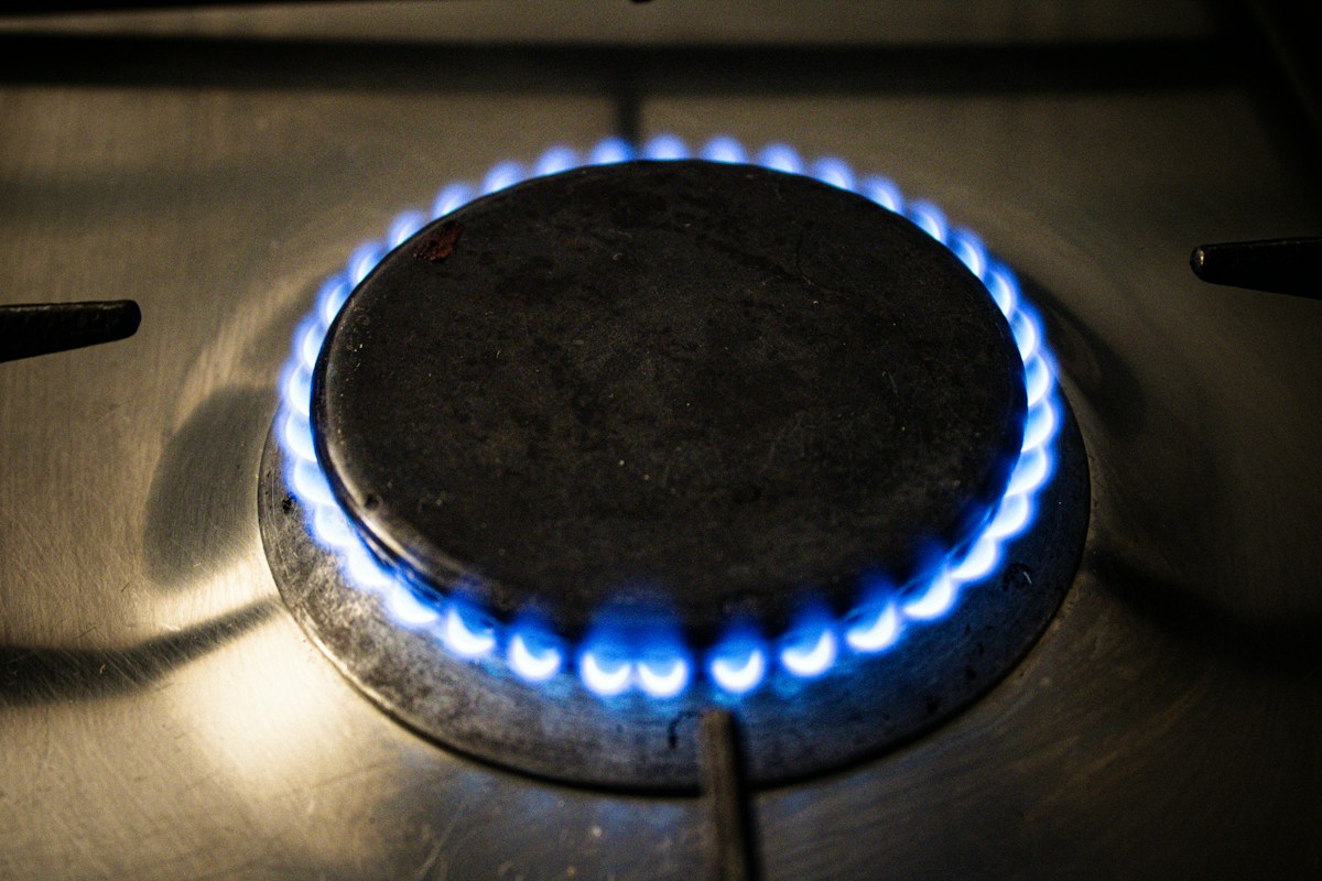 Brûleur de cuisinière à gaz allumé sous une plaque noire