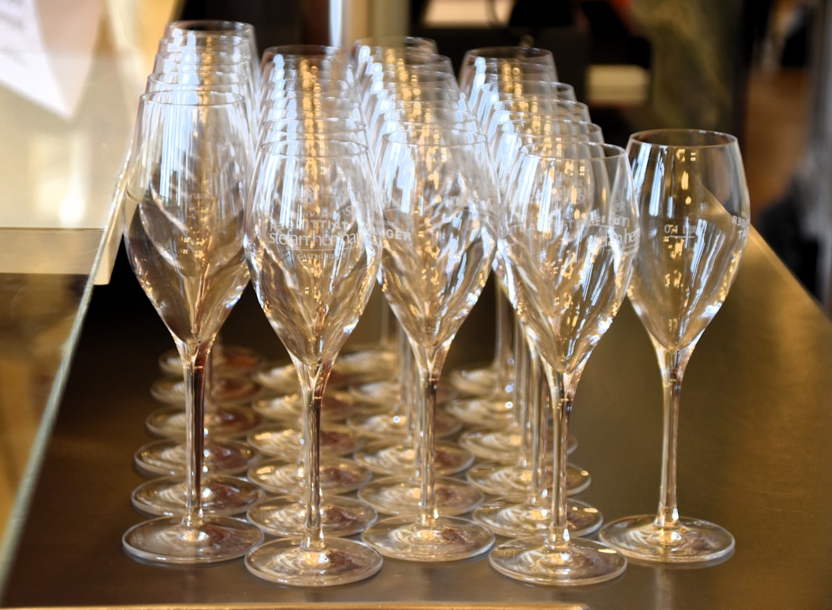 Verres de champagne cristallins alignés sur une surface brillante.