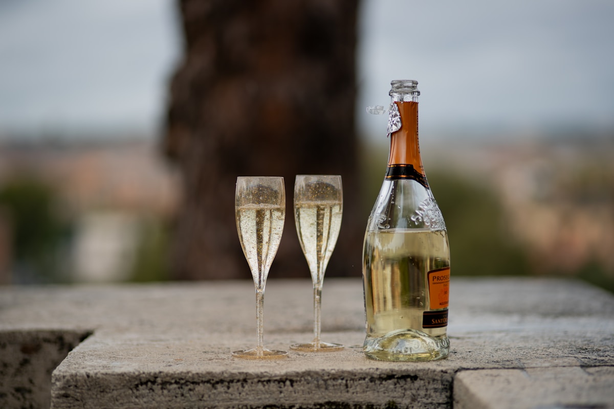 Bouteille de champagne et deux coupes sur un mur en pierre.