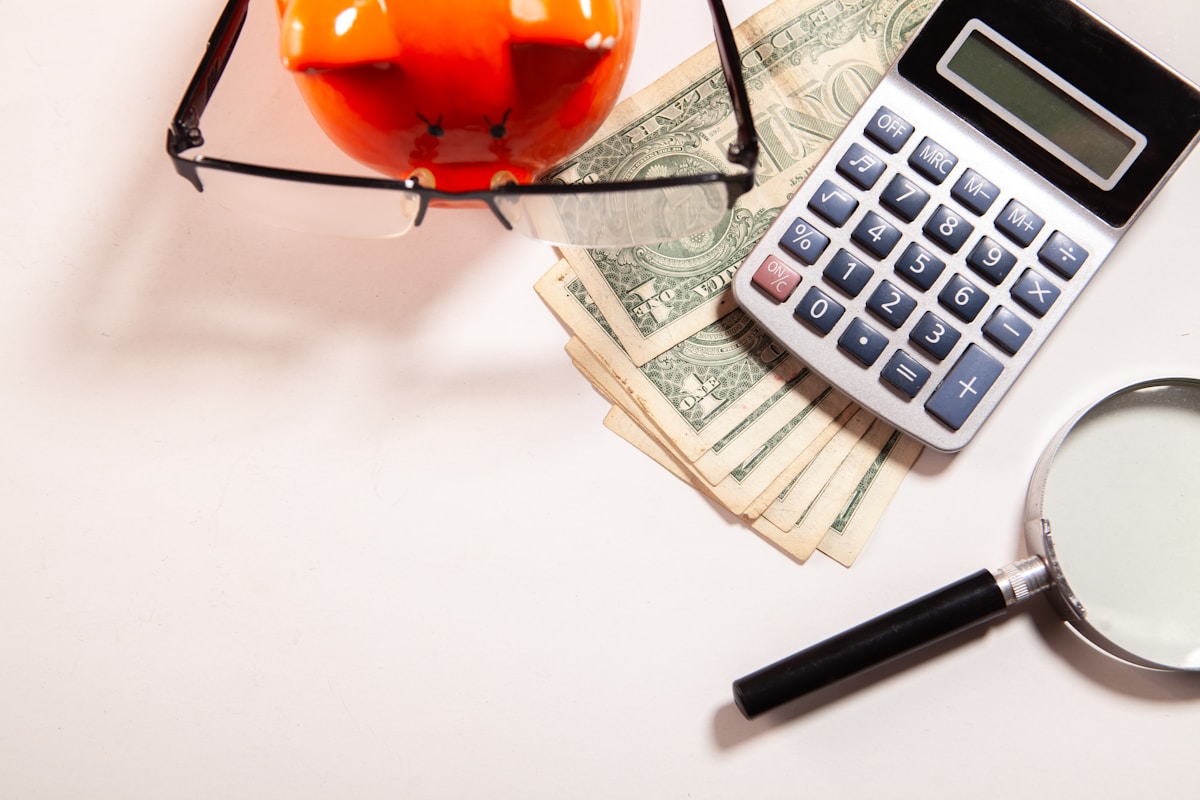 Calculatrice, lunettes, argent, loupe, objet rouge en verre.